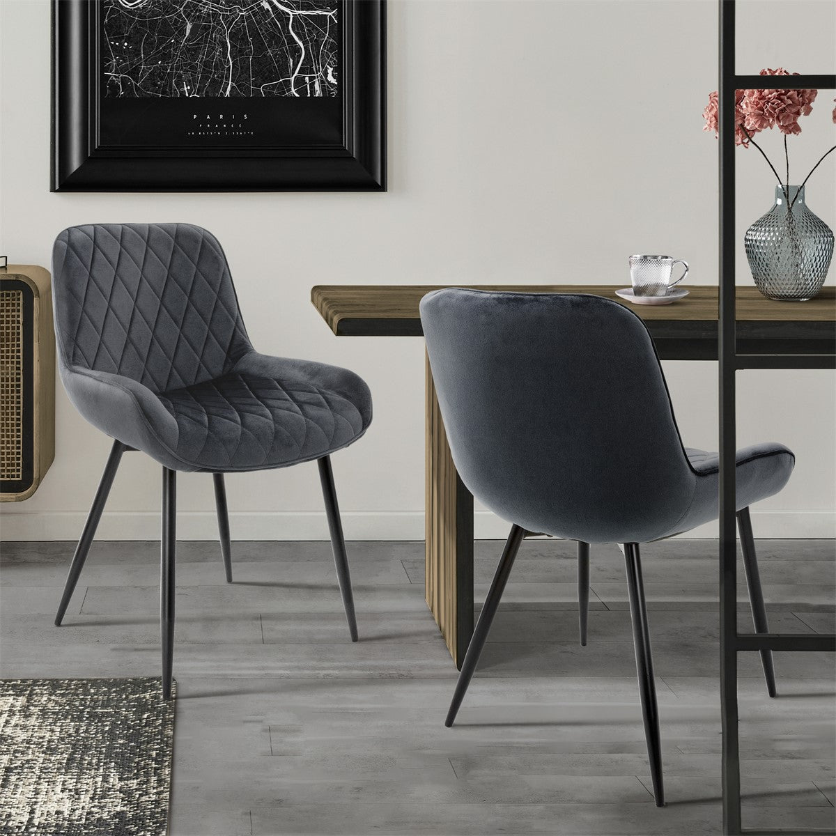 Two gray chairs at a table in a modern room with a window and a work of art.