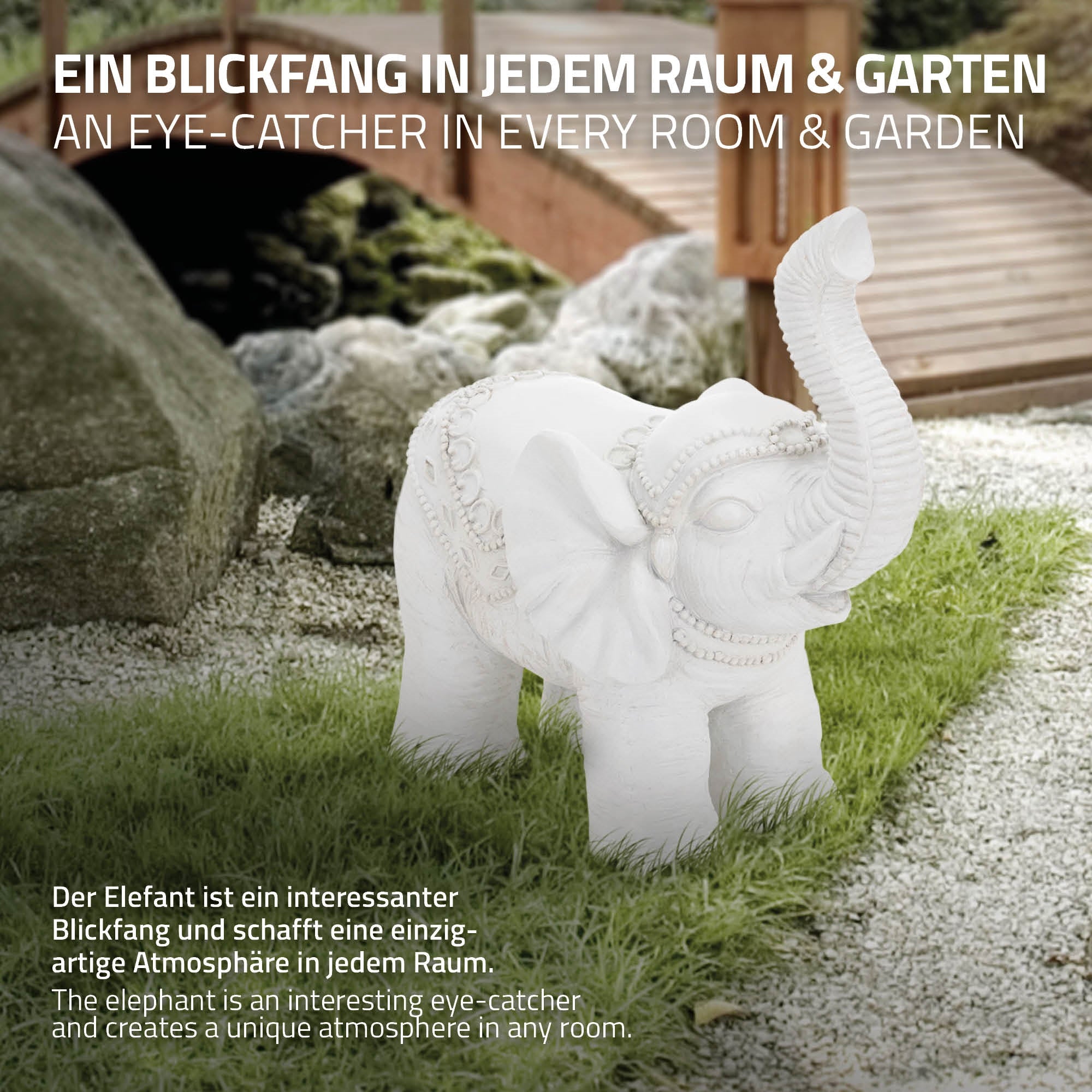 Ein dekorativer Elefant aus Stein auf einer Wiese, umgeben von Pflanzen.