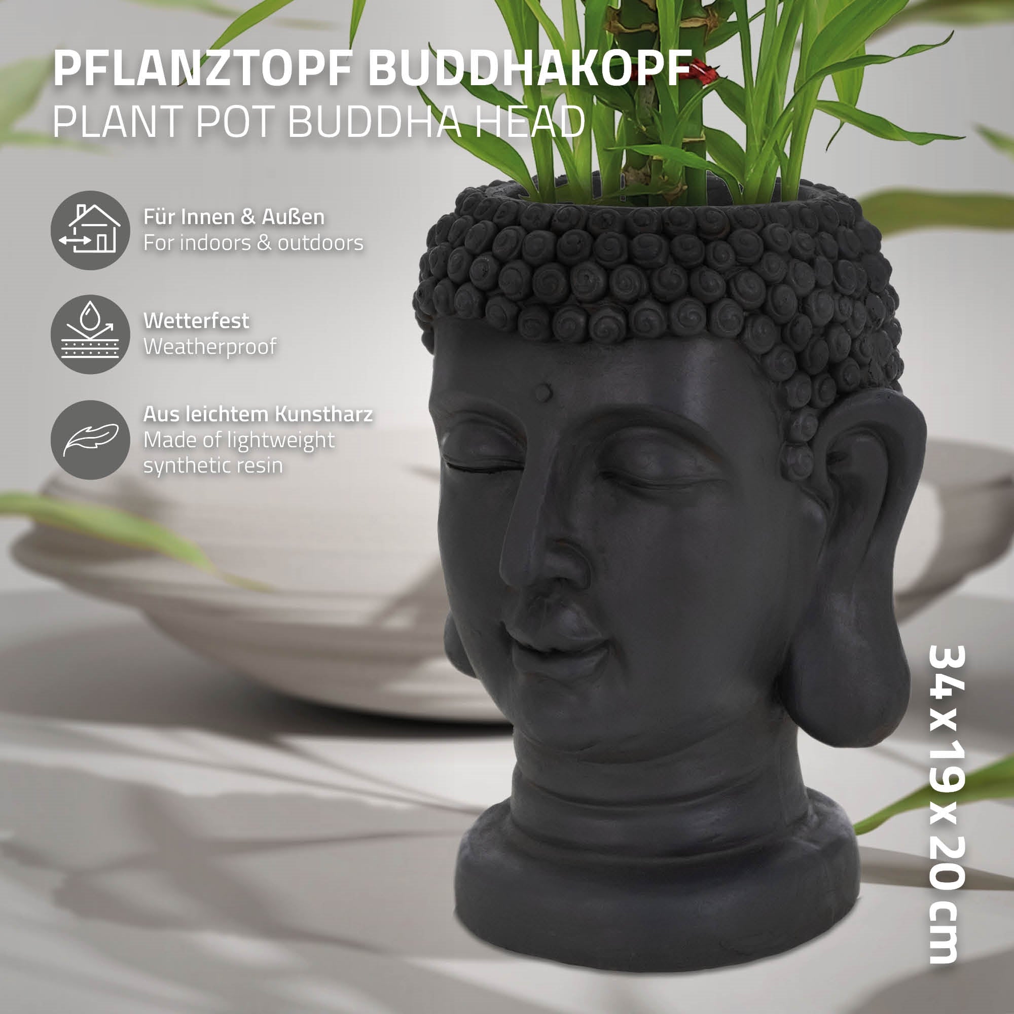 Schwarzer Pflanztopf in Form eines Buddha-Kopfes mit Pflanzen.
