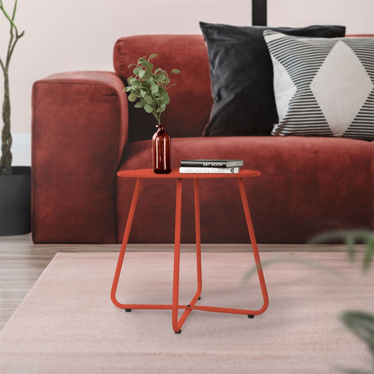 Roter Tisch mit runder Platte, dekoriert mit einer Vase und Büchern.