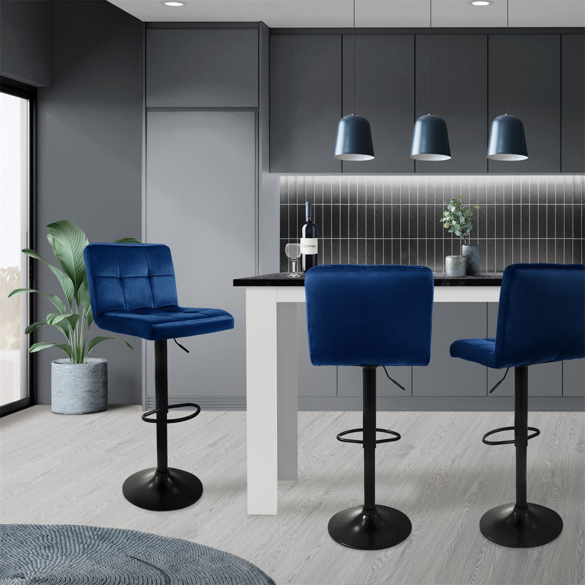 Moderne Küche mit blauen Barhockern an einem weißen Tisch.