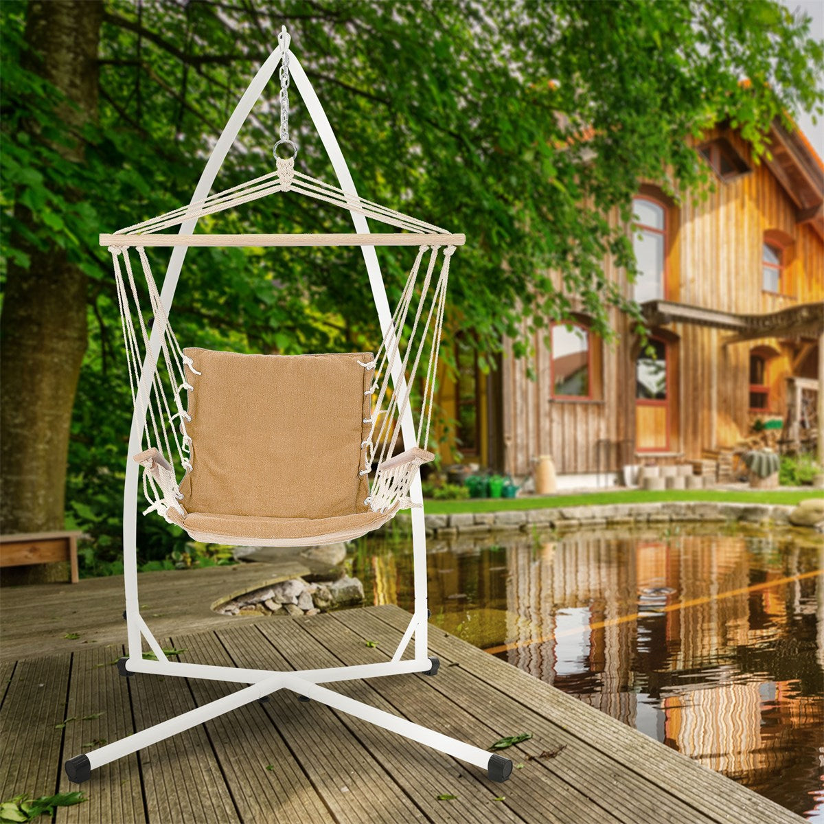 Hängesessel mit beige Kissen, auf einer Holzterrasse vor einem Holzhaus.