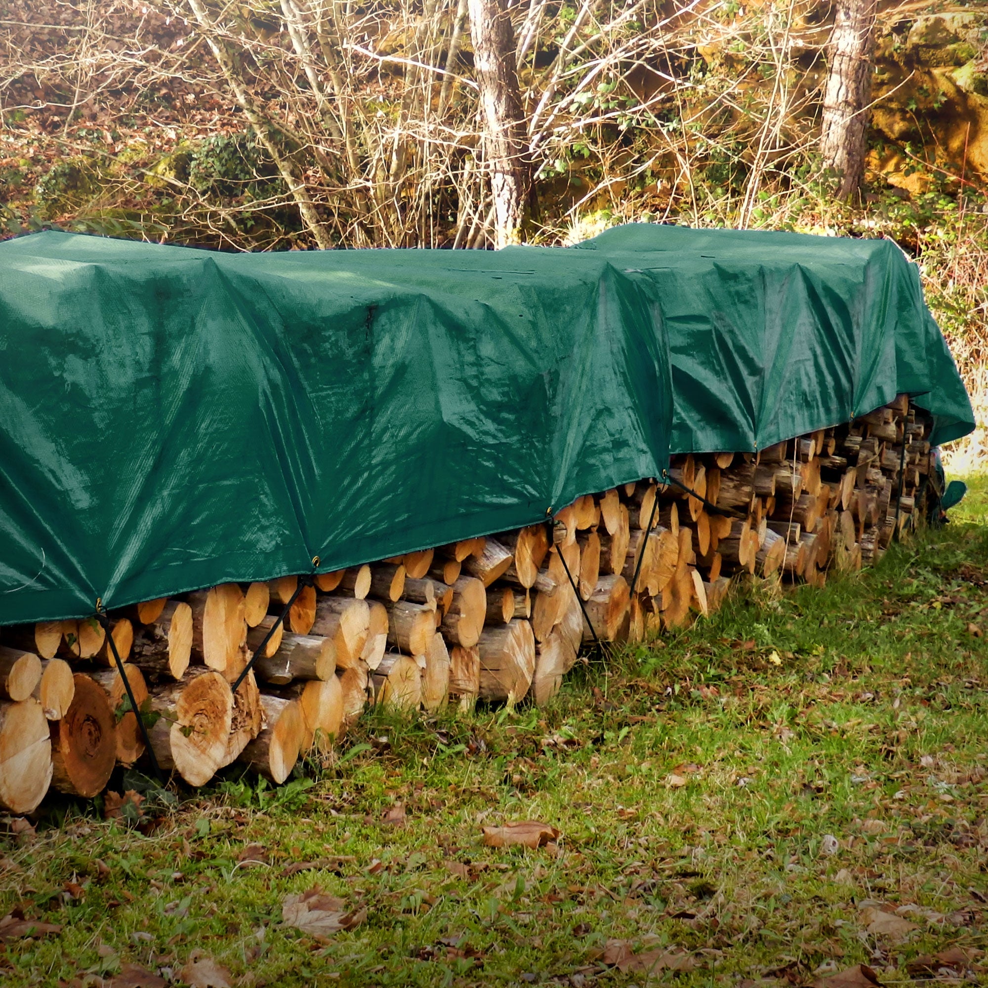 Grüne Plane, verwendet zum Abdecken von Holzstapel im Freien.