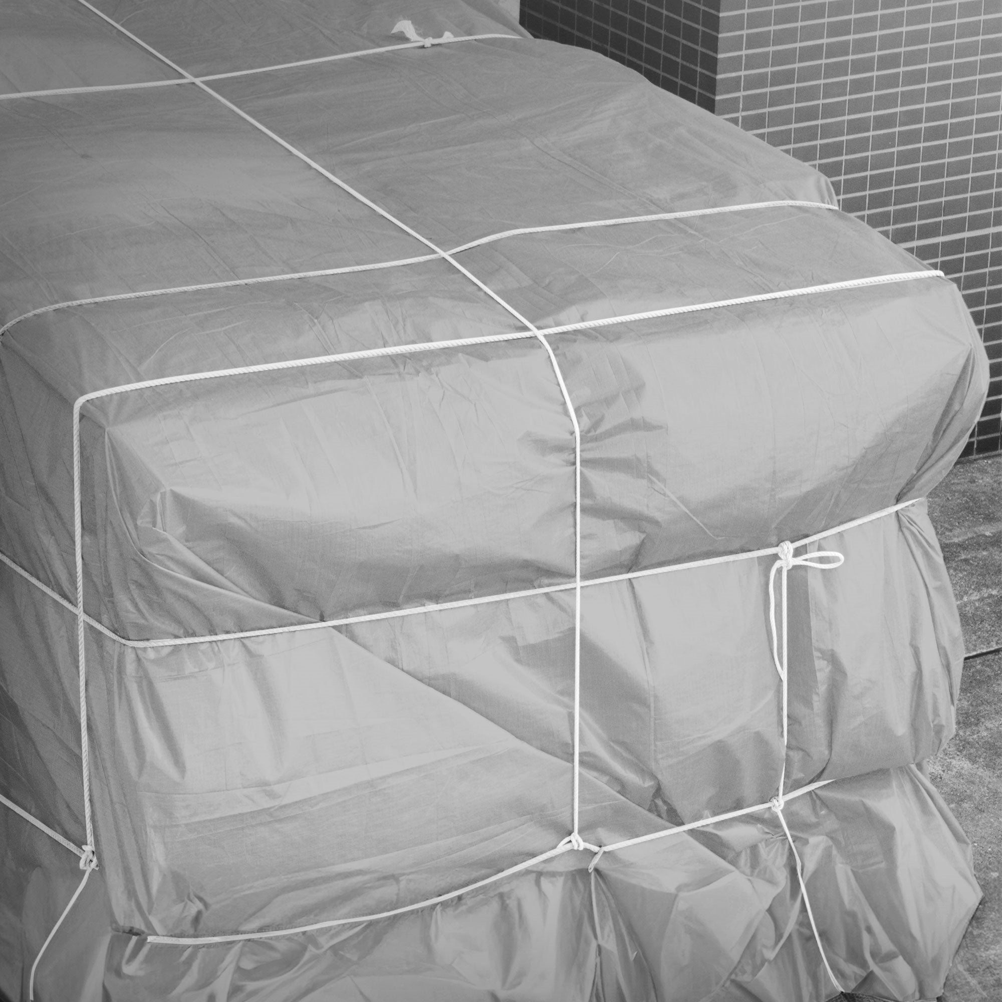 Gray tarp, tied together, on a stack.