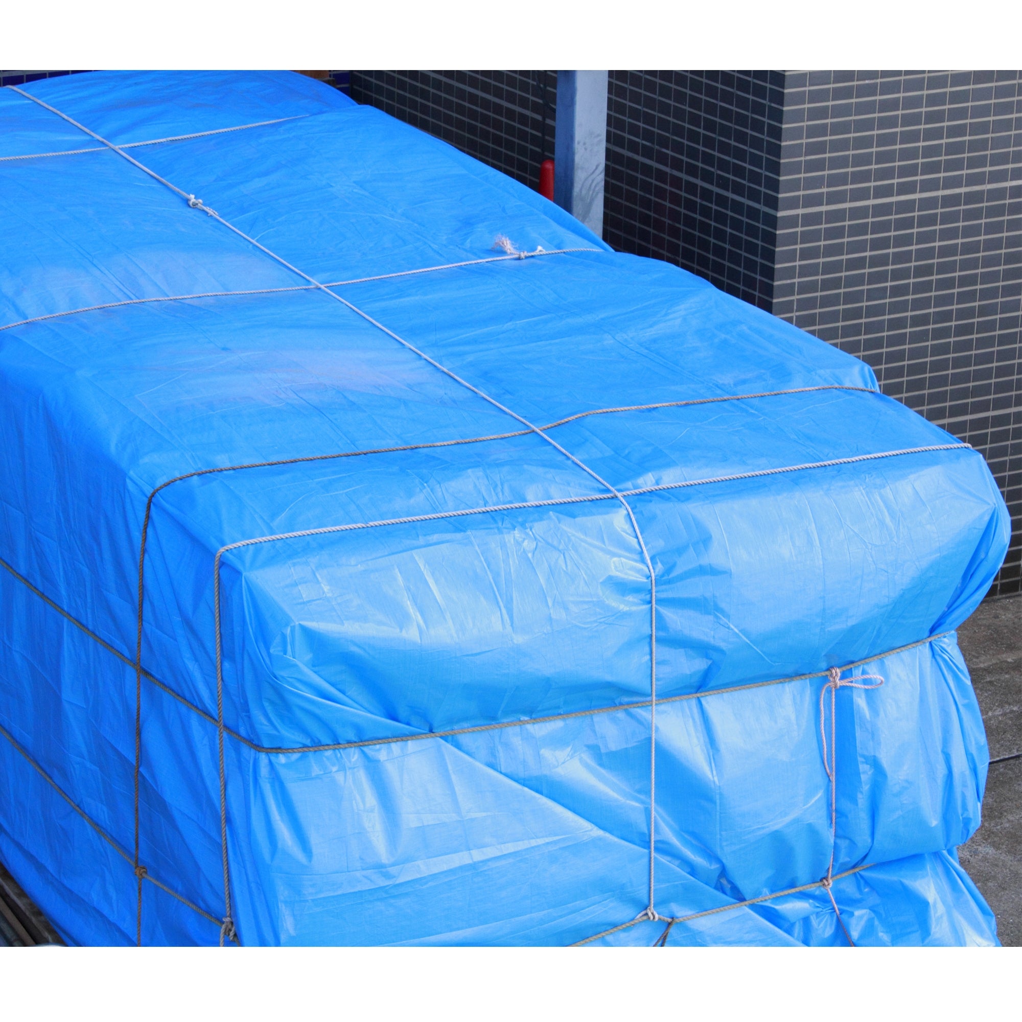 Ein blauer Planenstoff, der auf einem Stapel von Materialien liegt.