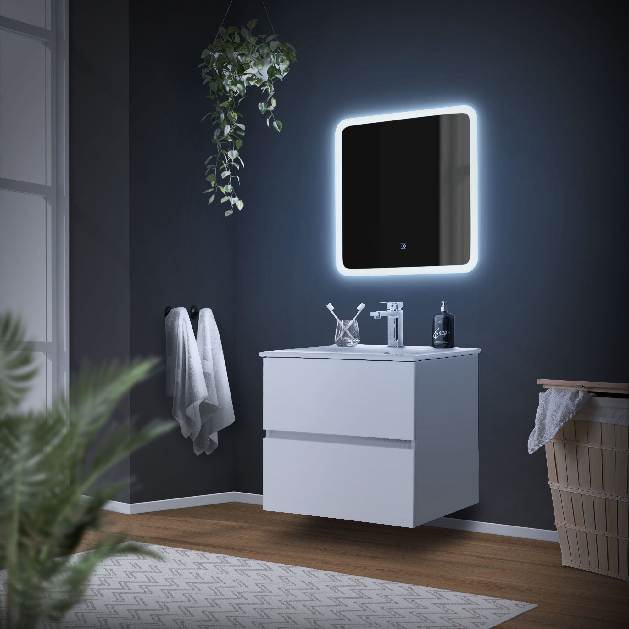 Baño con espejo iluminado, lavabo y toallas.