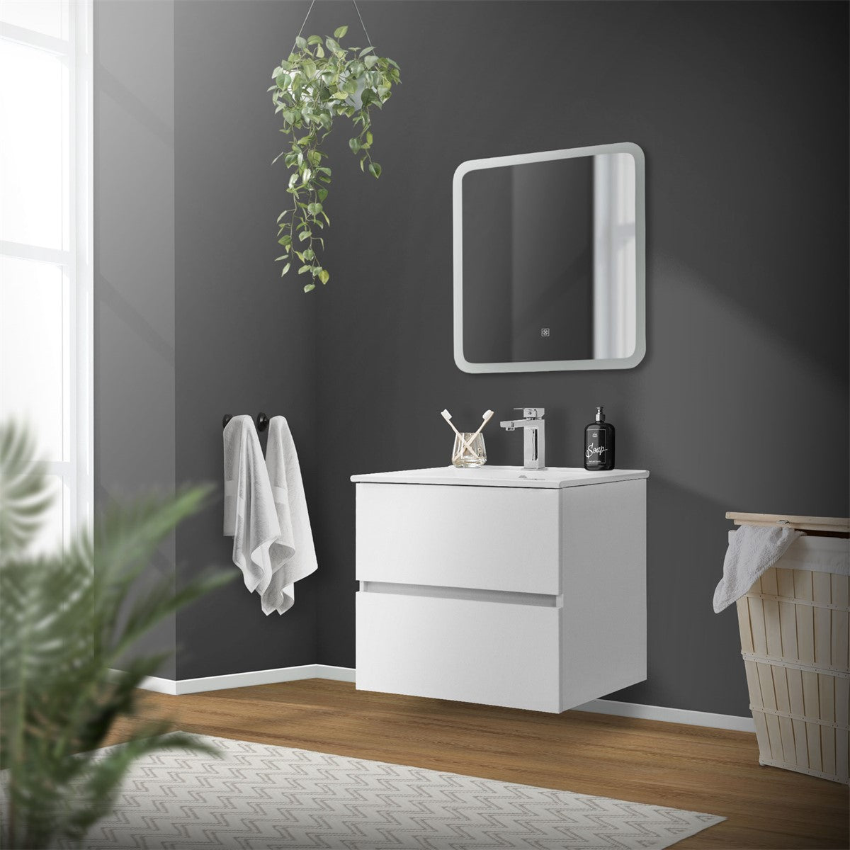 Badezimmer mit weißem Waschbecken, Spiegel und Pflanzen an der Wand.