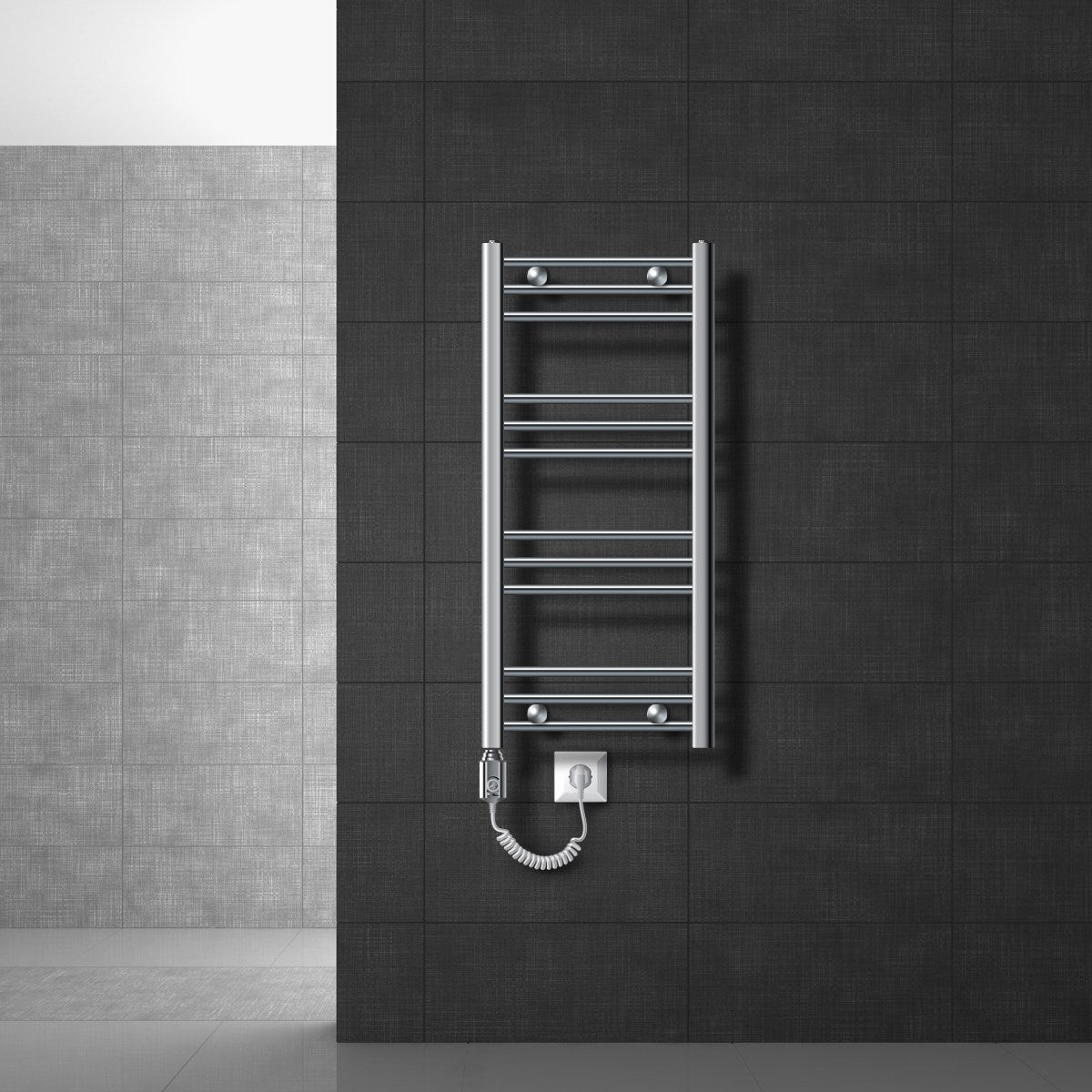 Kleiner chromfarbener Handtuchheizkörper an einer dunklen Wand.