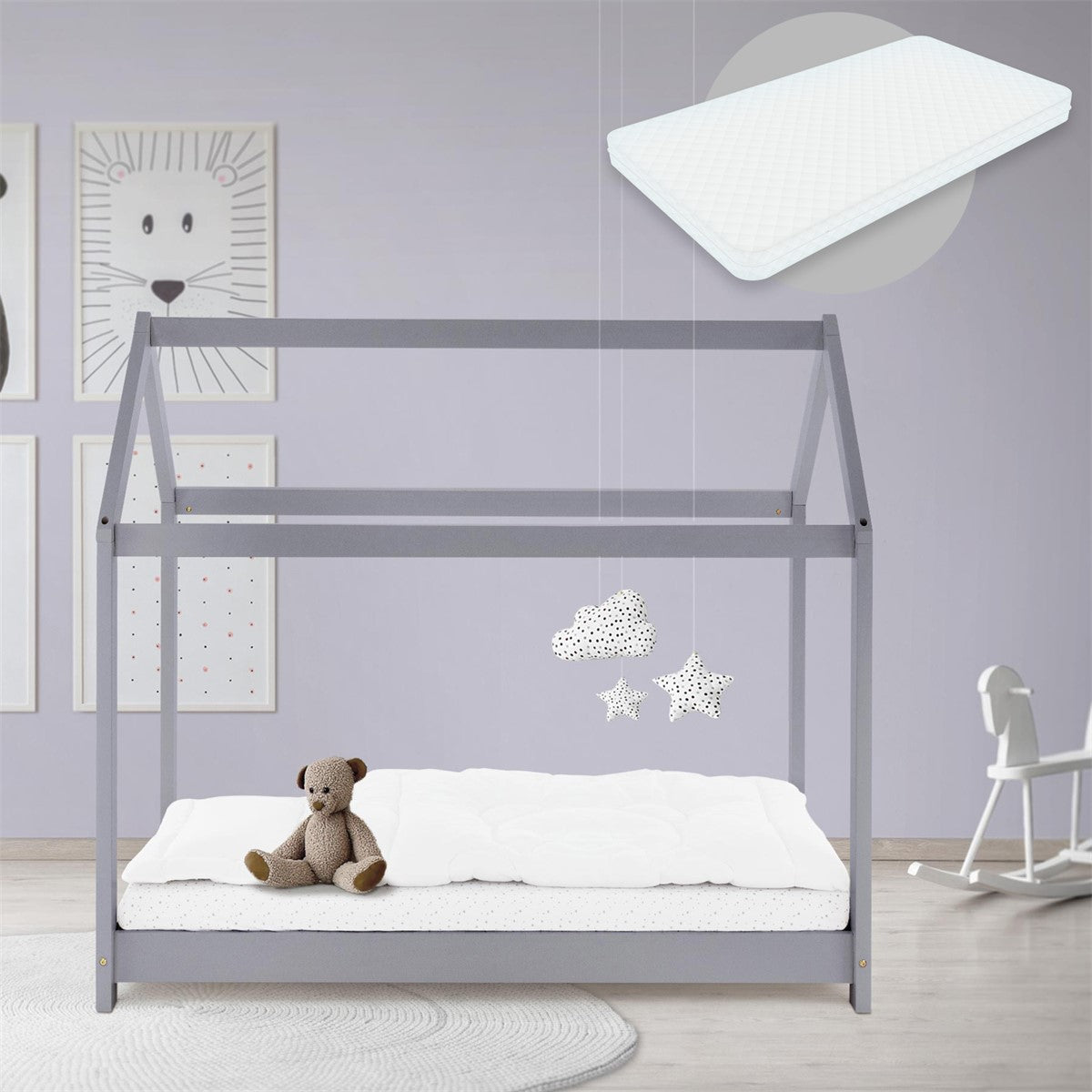 Ein Kinderbett im Hausdesign mit einem Teddy und einer Matratze.