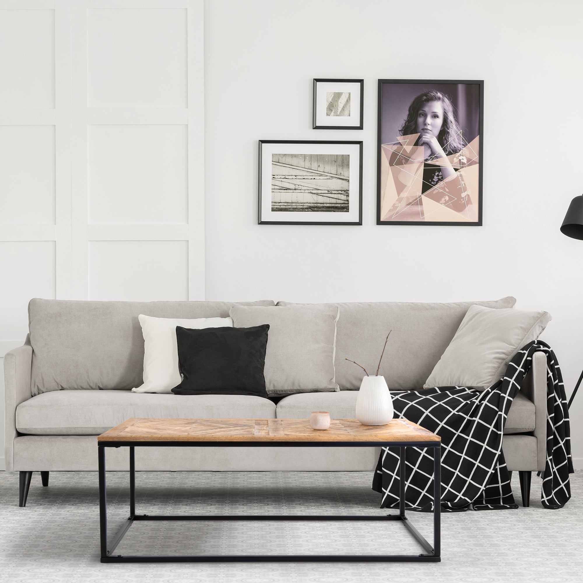 Gray sofa with cushions, table, and pictures in a bright room.