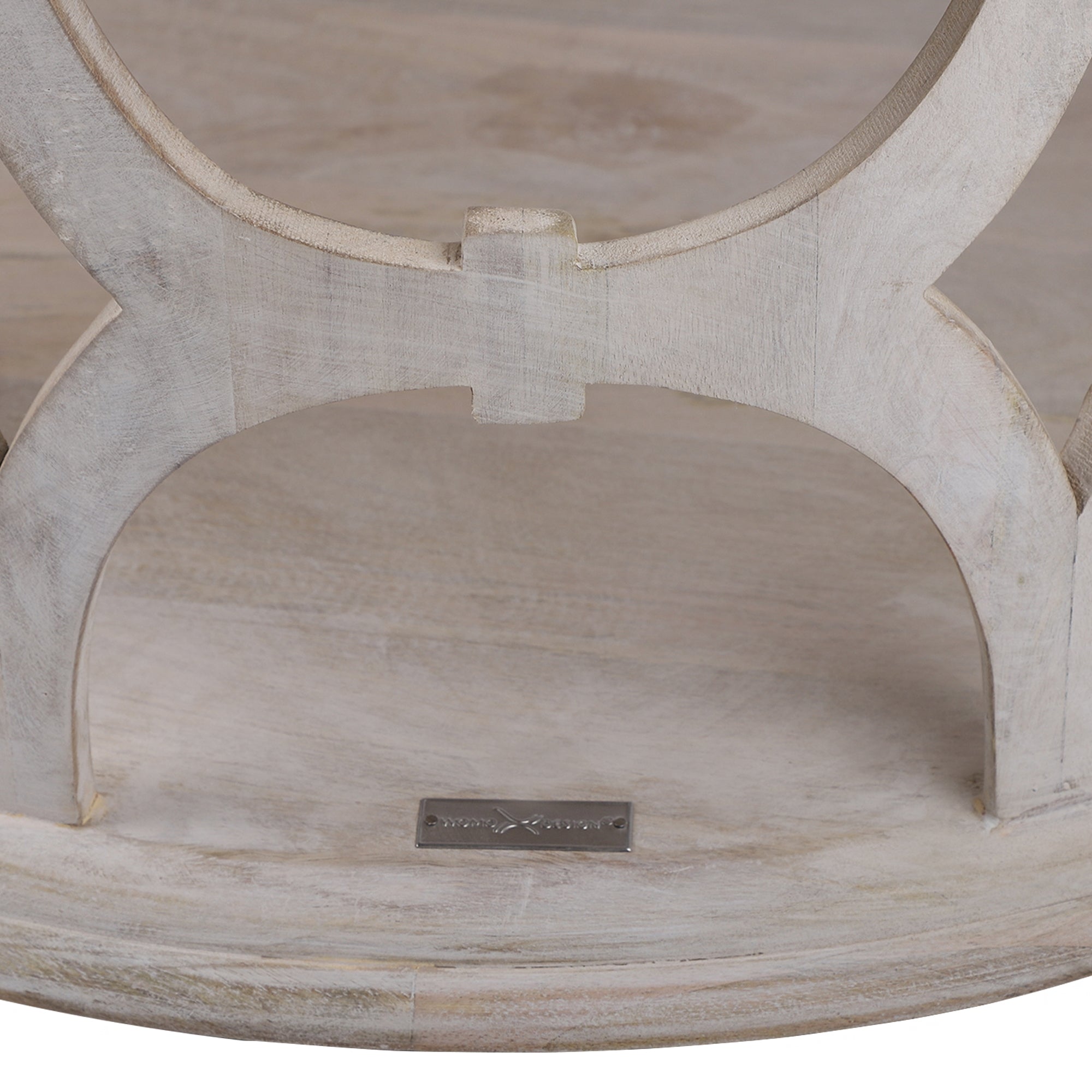 Unterseite eines Möbelstücks aus hellem Holz mit einem kleinen Metallschild.