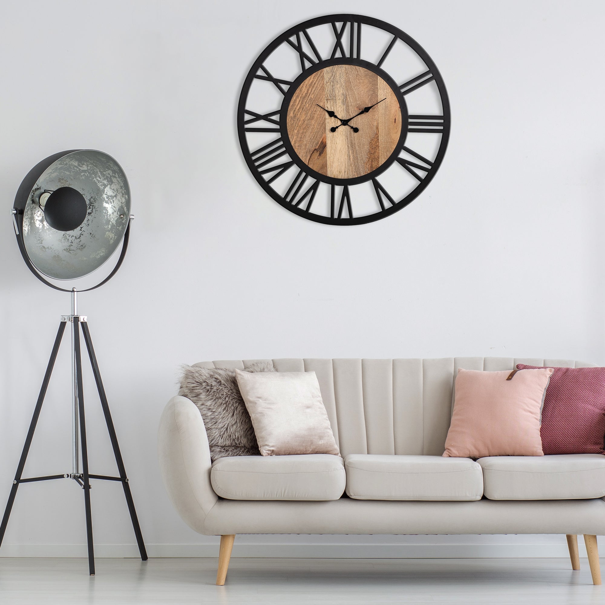 Ein modernes Wohnzimmer mit einer schwarzen Wanduhr und einem hellen Sofa.