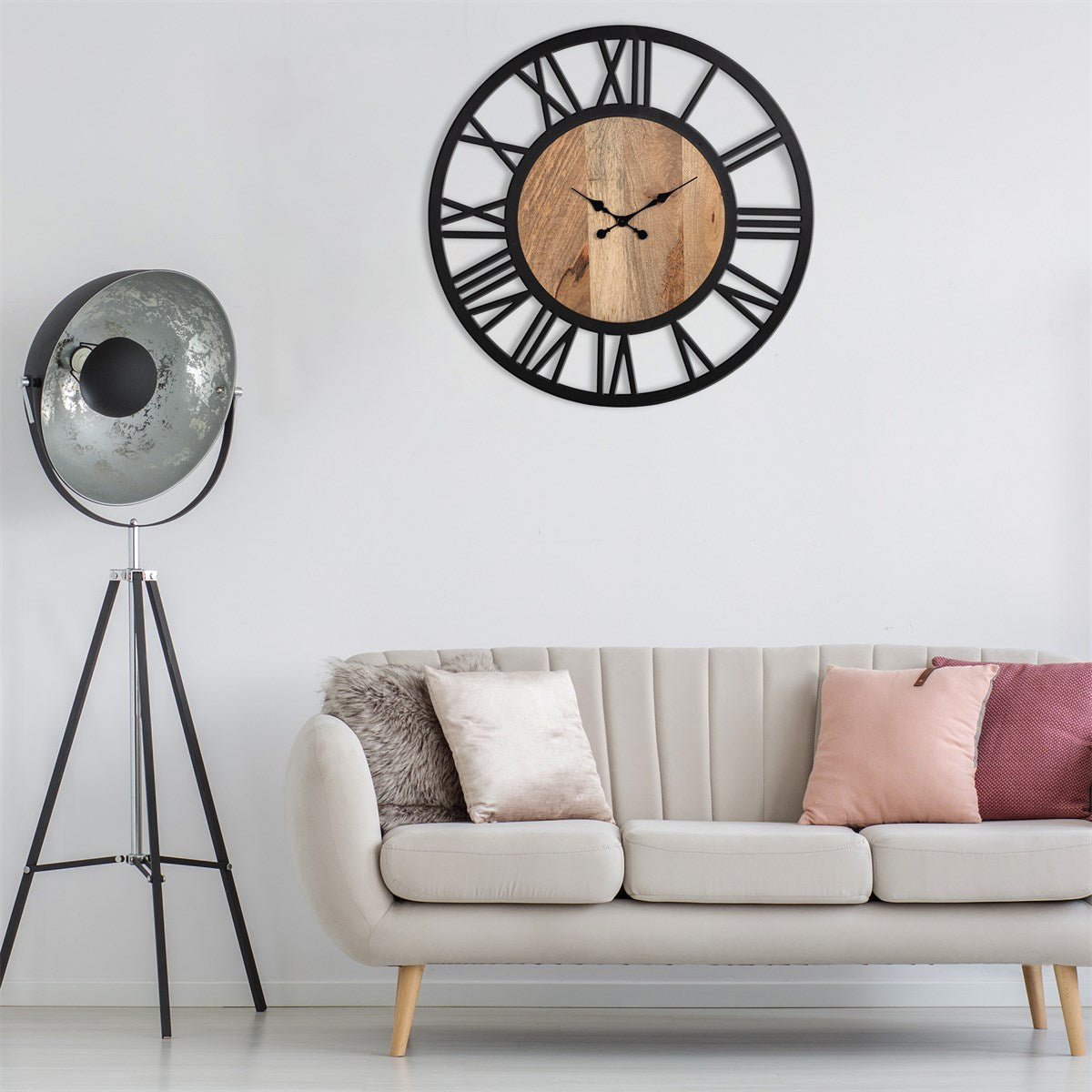 Un salón moderno con un reloj de pared negro y un sofá de color claro.