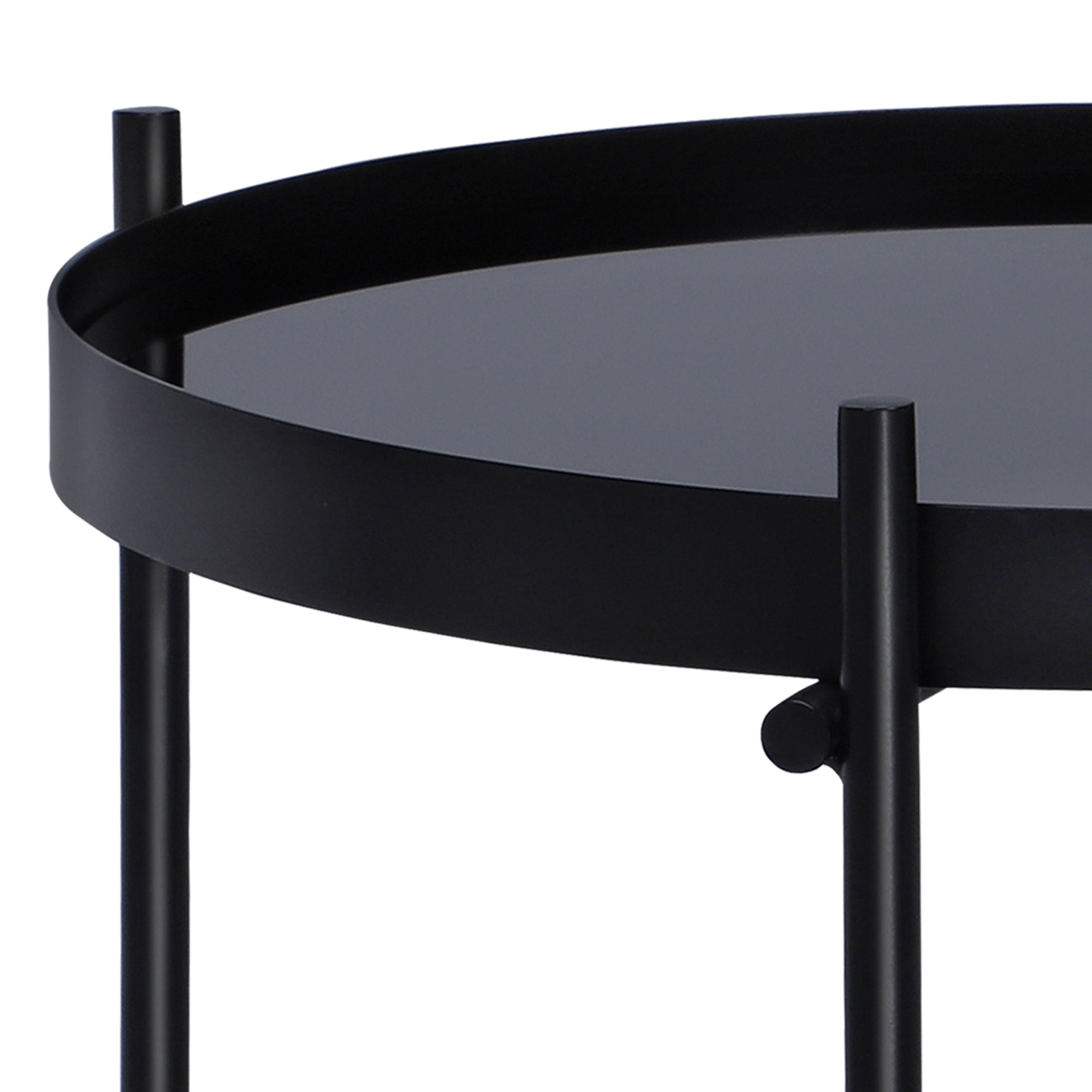Close-up of a black side table with a round tabletop and sturdy legs.