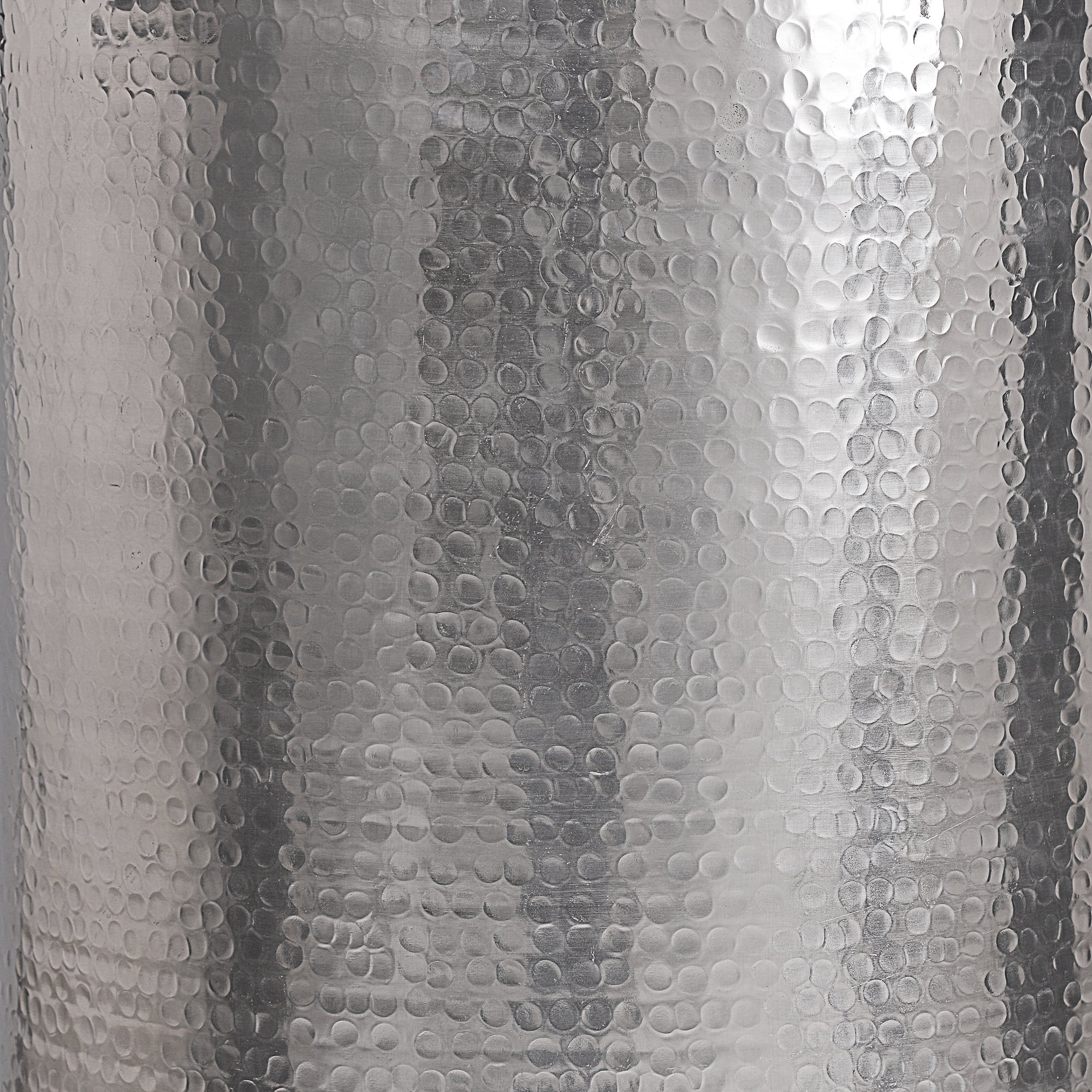 Close-up of the surface of a silver table with a shiny, textured surface.