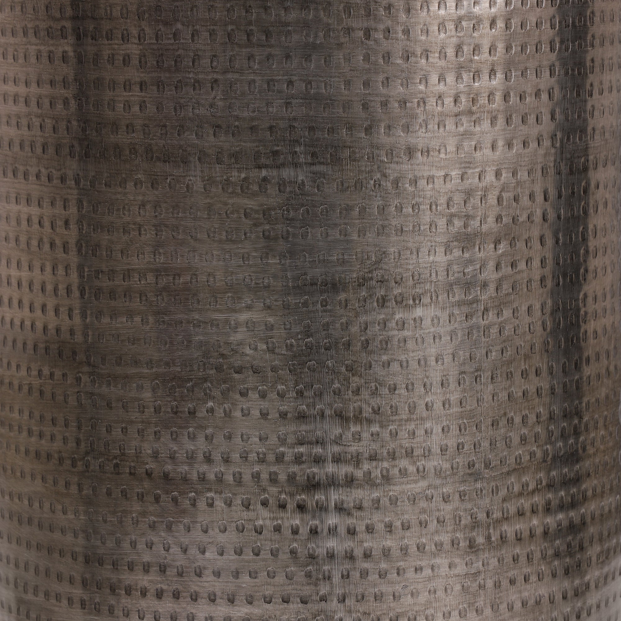 Close-up of the surface of a metallic table with a textured, shiny surface.