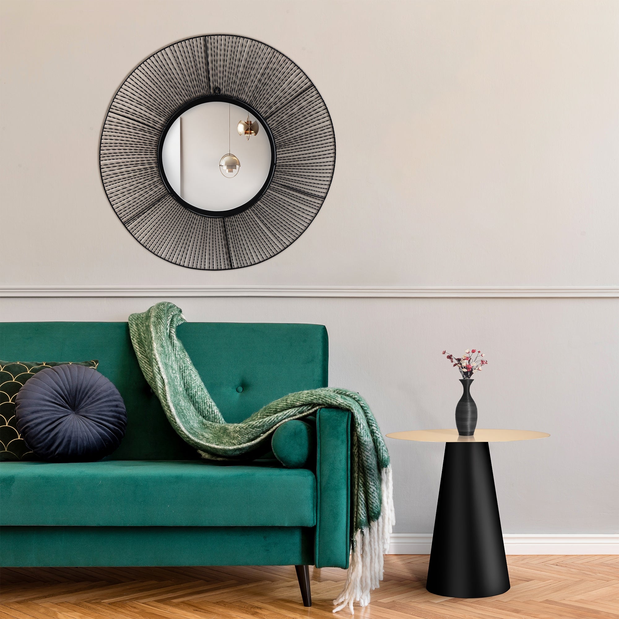 Wohnzimmer mit grüner Couch, schwarzem Tisch und Wandspiegel.