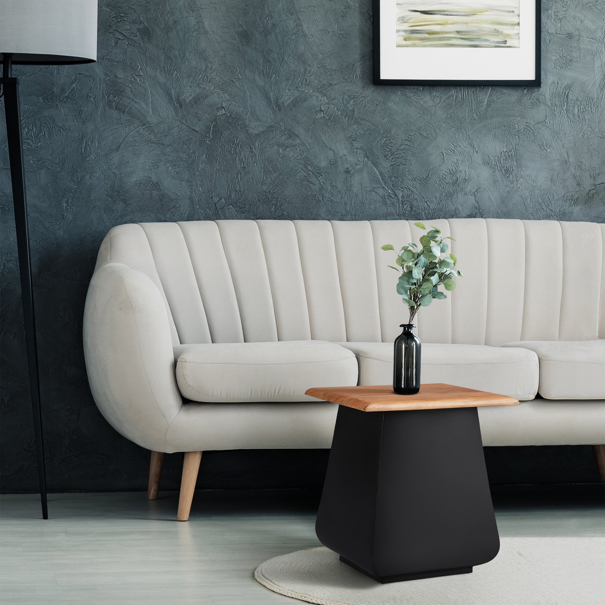 Salon avec un canapé beige, une table et une plante sur la table.