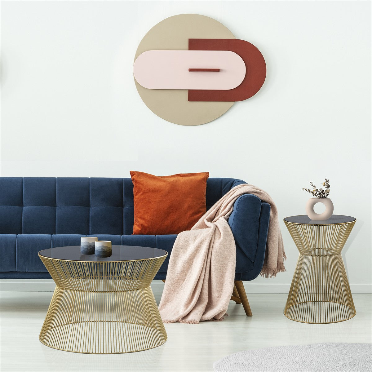 Ein blauer Sofa mit Kissen, einem Beistelltisch und einer Wanddekoration.