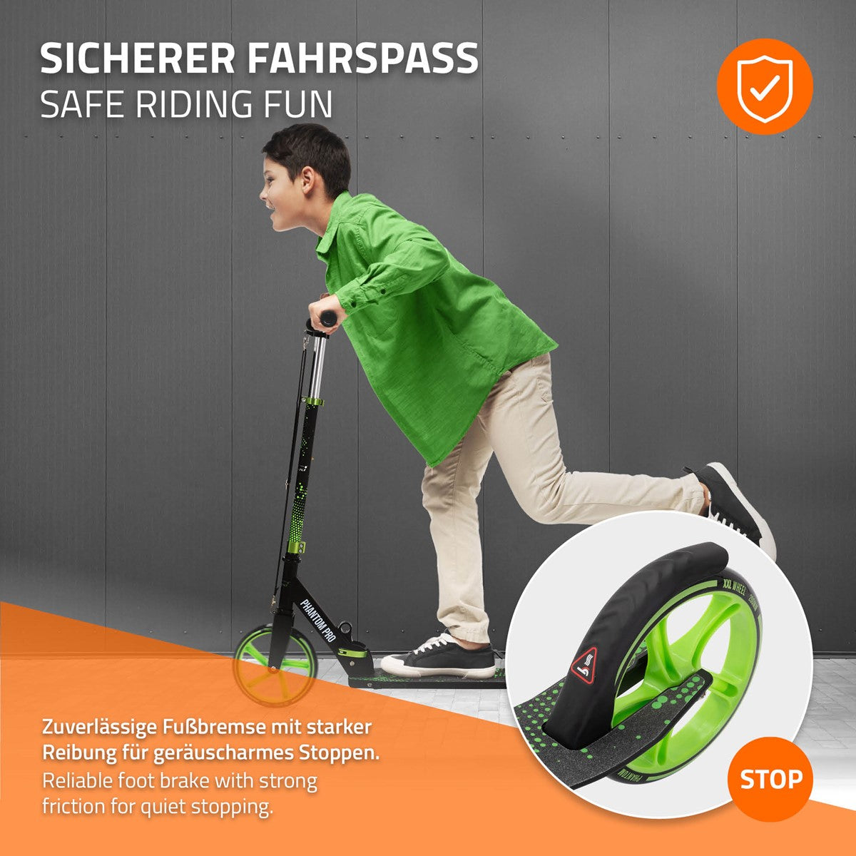 Junge fährt auf einem Scooter mit grünem Rahmen, auf grauem Hintergrund.