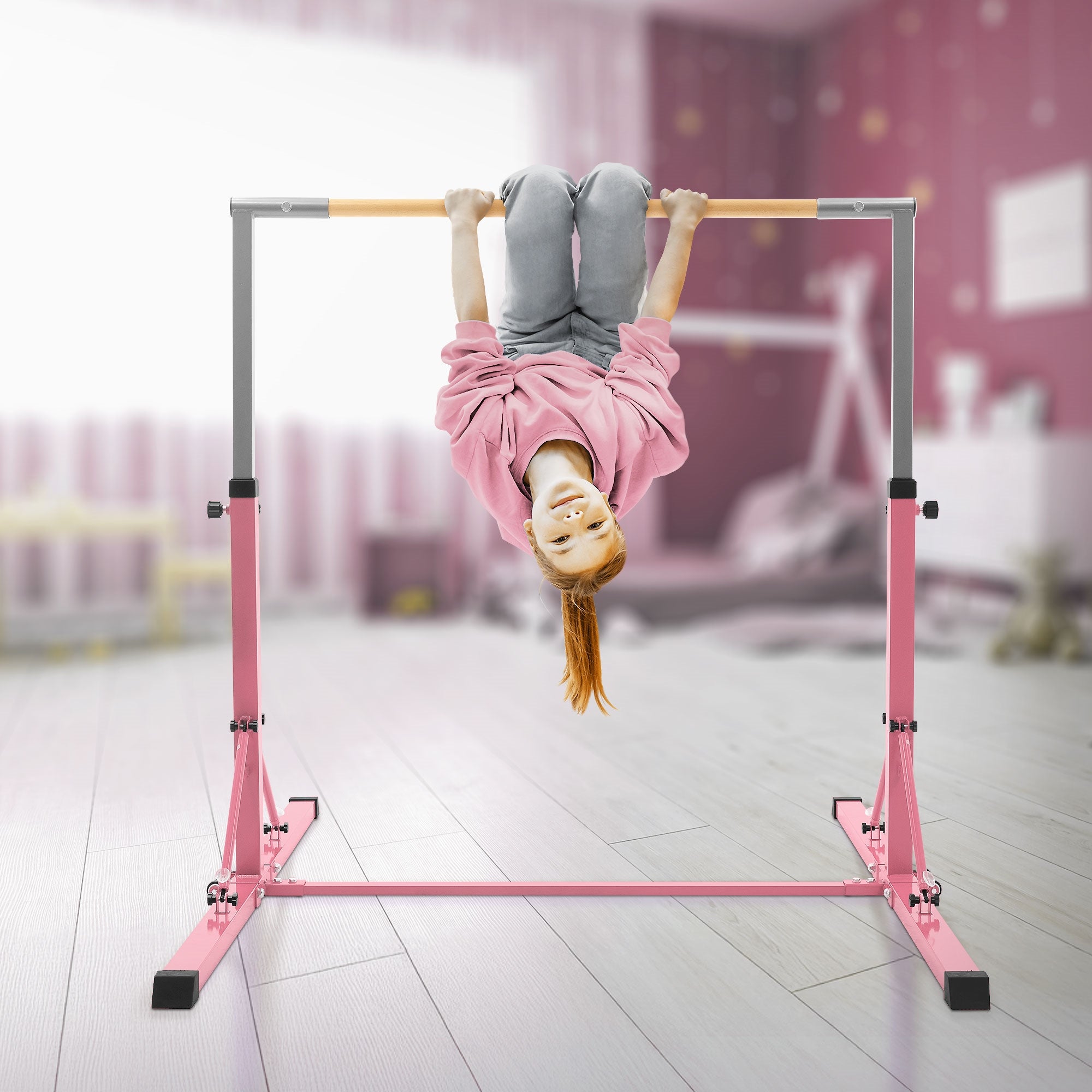 Mädchen hängt kopfüber an einer Trainingsstange in einem rosa Raum.