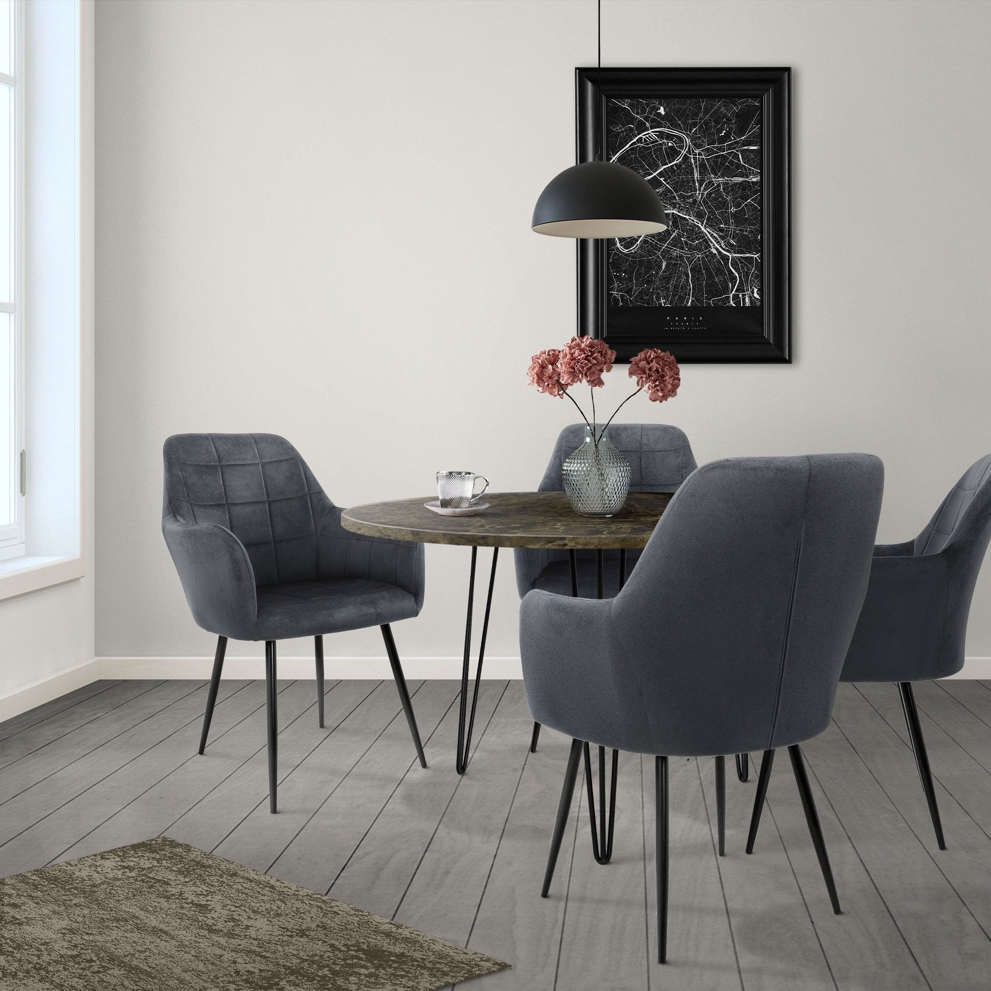 Una mesa redonda con cuatro sillas grises en una habitación luminosa.