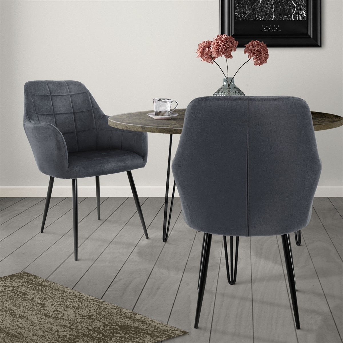 Two gray chairs at a table with a vase and flowers.