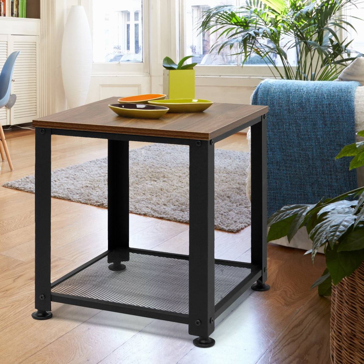 Una mesa en la sala de estar con decoración y plantas al fondo.