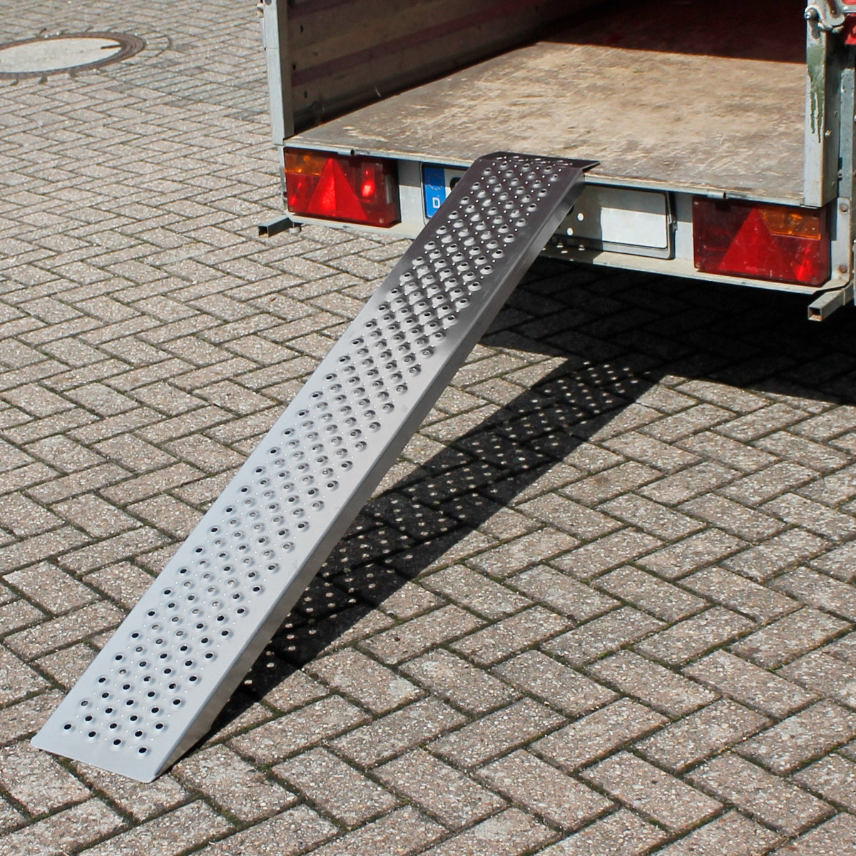 Een metalen helling die aan een vrachtwagen is bevestigd.