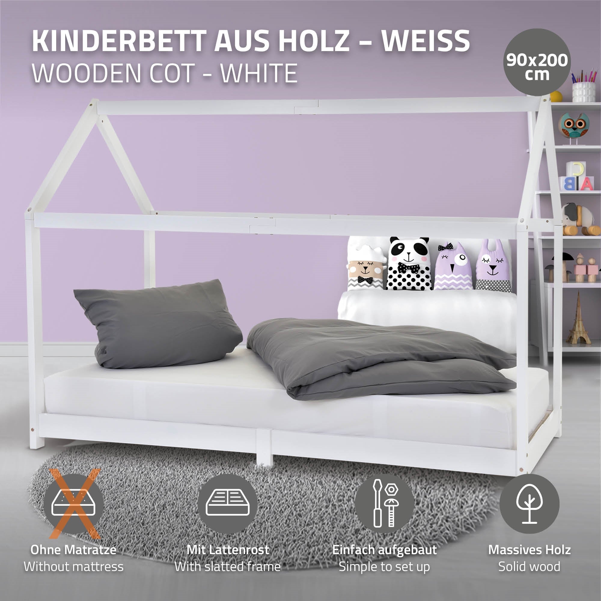 Weißes Kinderbett mit Lattenrost und Kissen auf der Liegefläche.