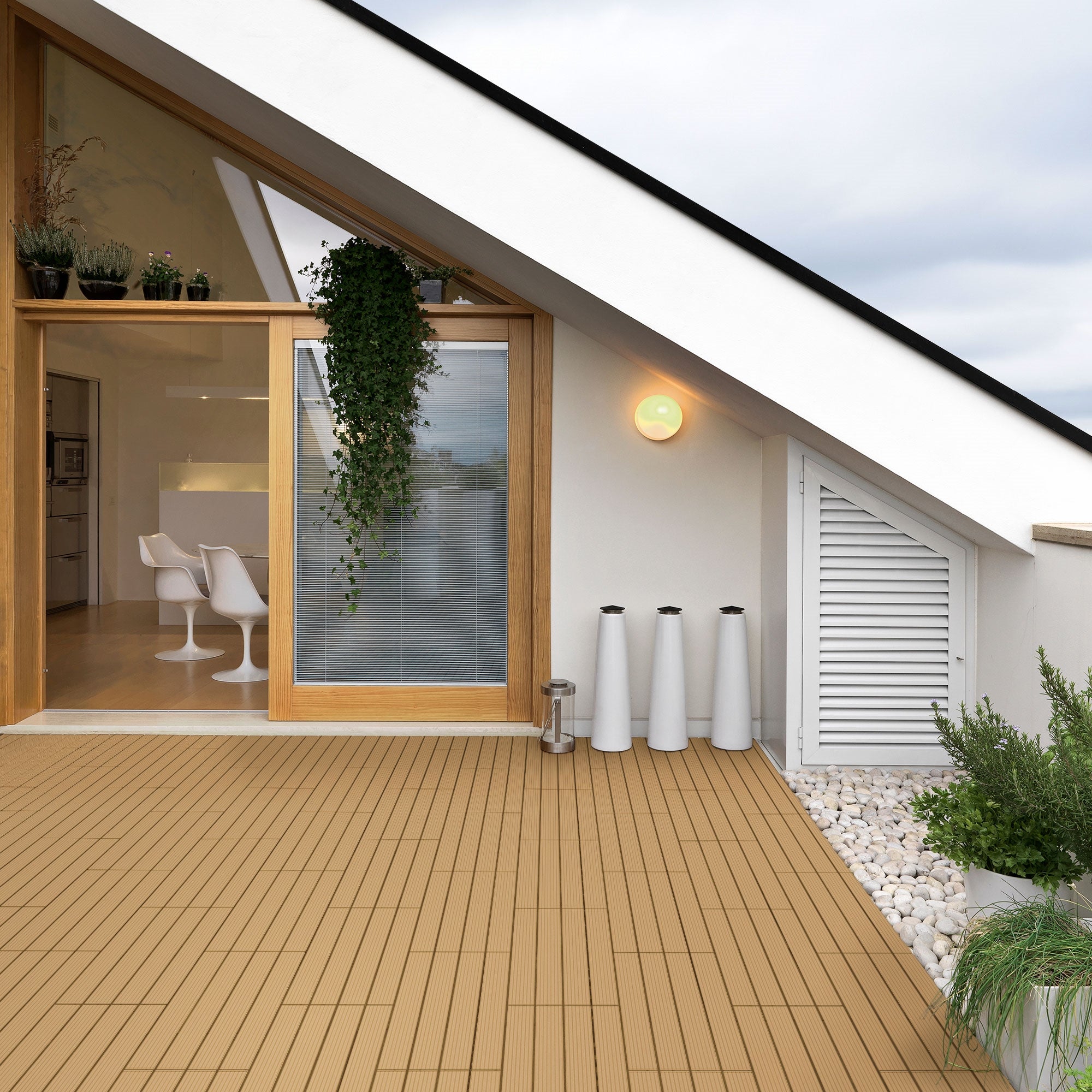 Terrasse mit WPC-Fliesen, Pflanzen und einem großen Fenster.