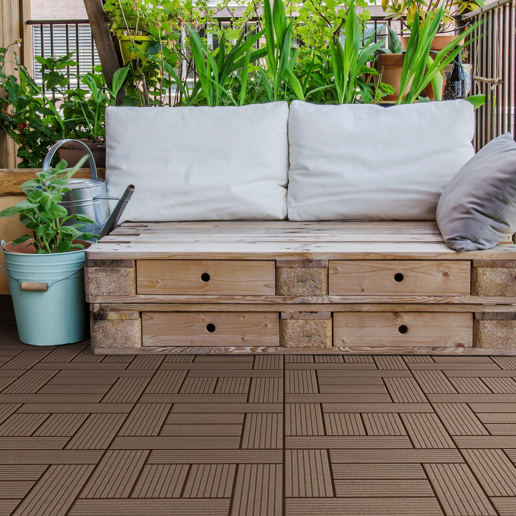 Banco de madera con cojines y plantas sobre un suelo de baldosas.