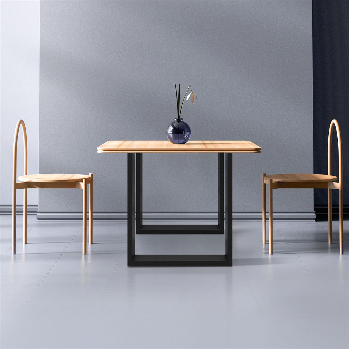 Tisch mit Holzplatte und zwei Stühlen in einem minimalistischen Raum.