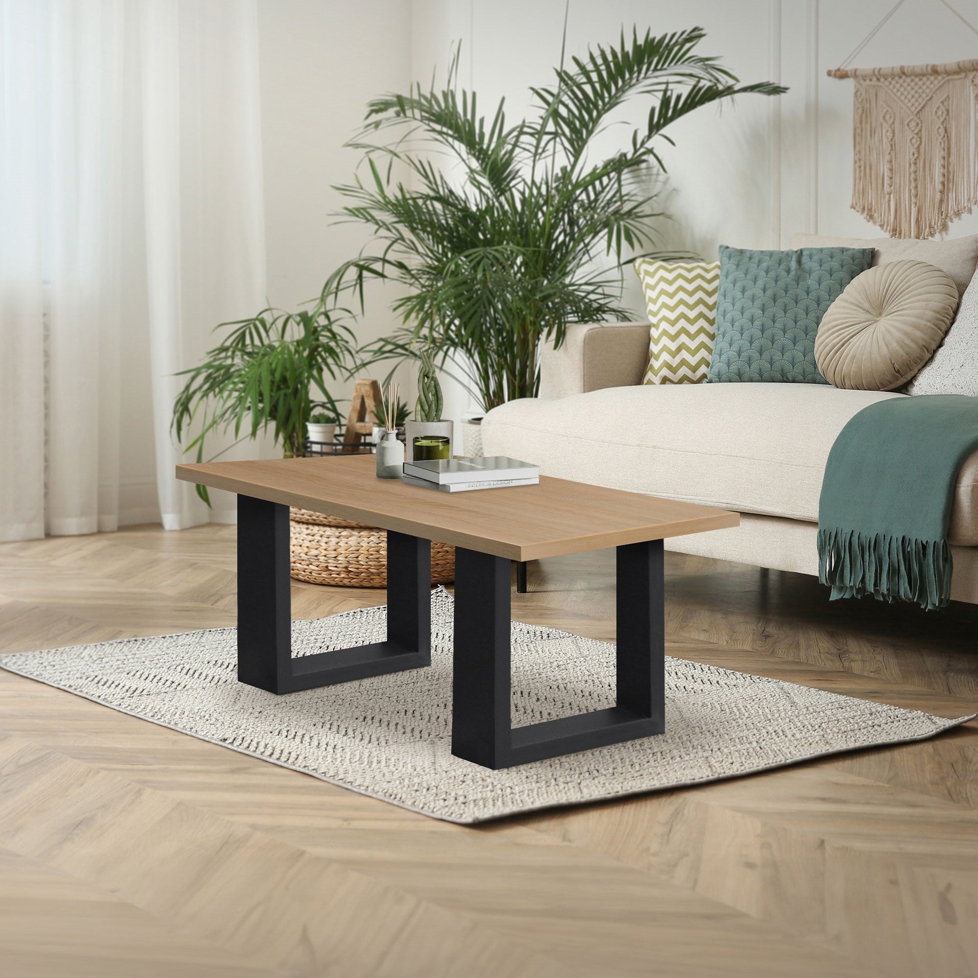 A modern coffee table made of wood with black legs in a bright living room.
