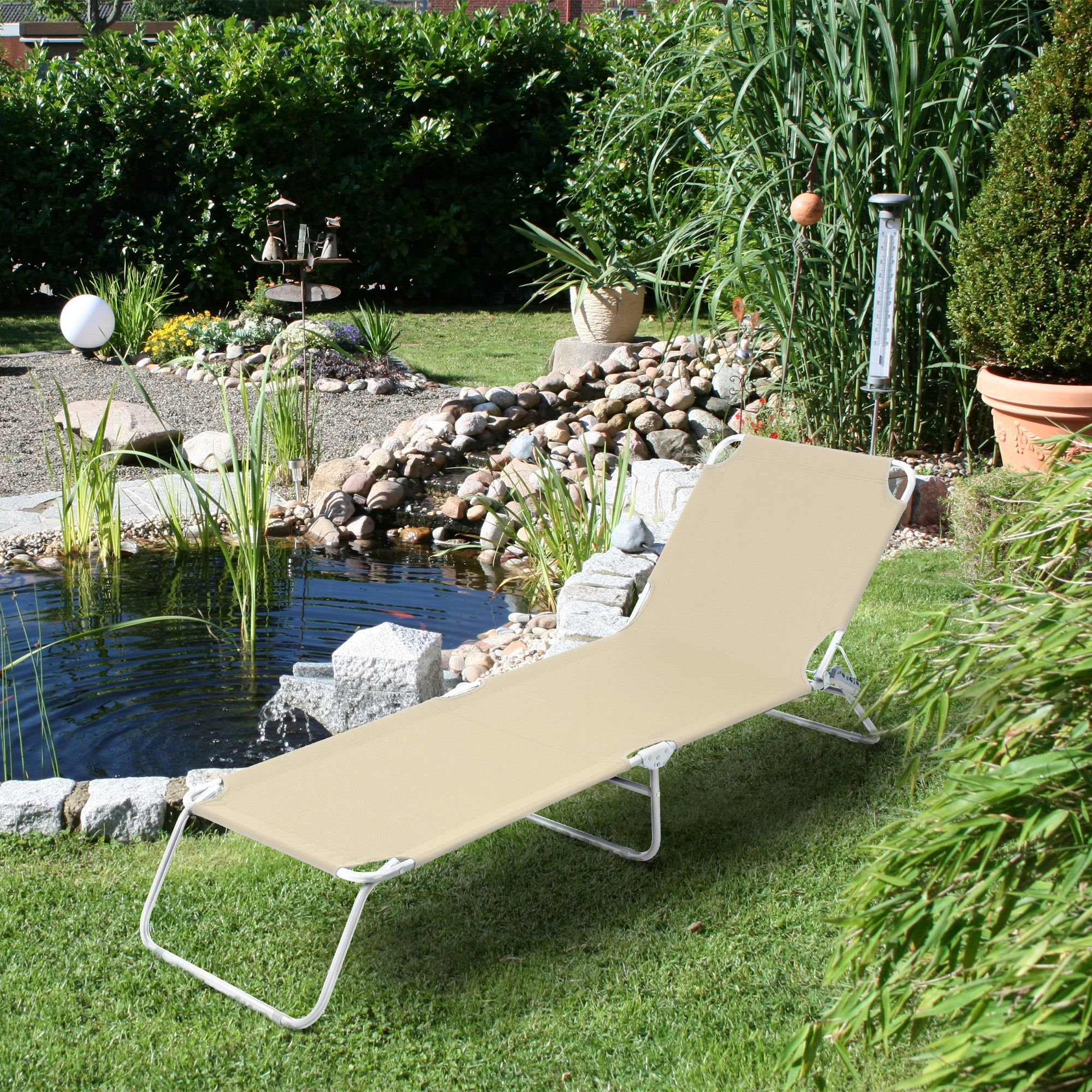 Liege im Garten neben einem Teich, umgeben von Pflanzen.