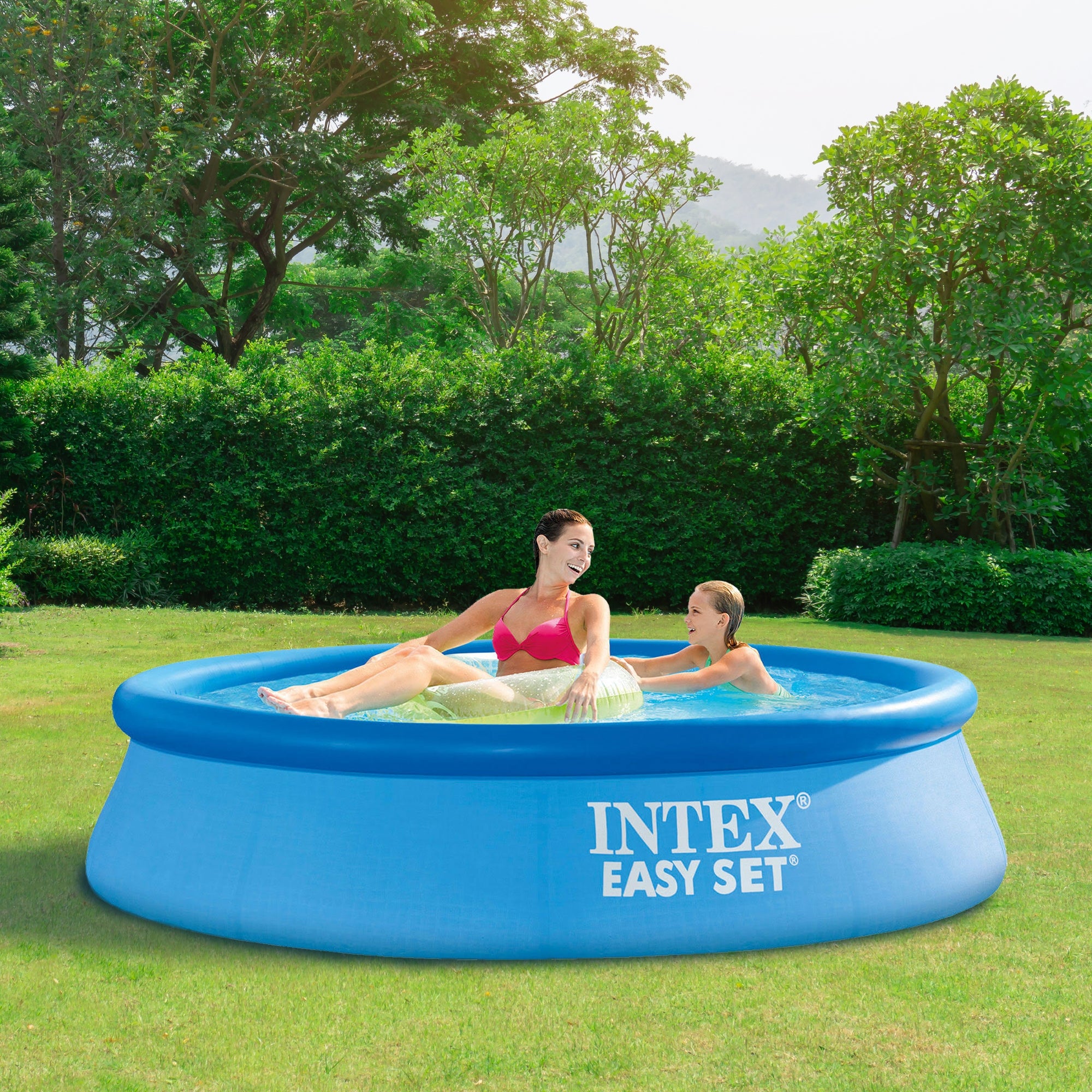 Eine Frau und ein Kind sitzen in einem aufblasbaren Pool im Freien.