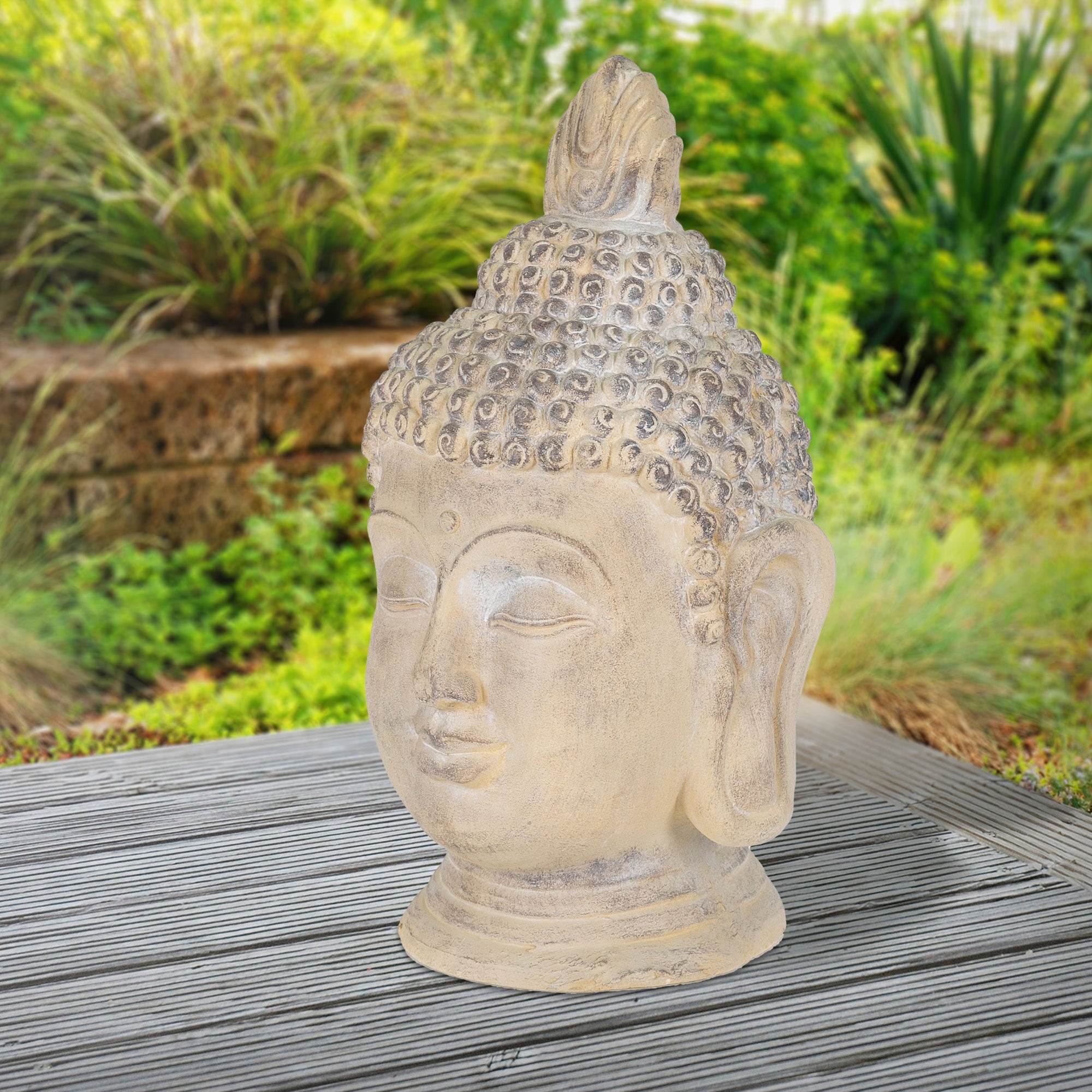 Buddha-Kopf beige, im Freien auf Holzuntergrund.