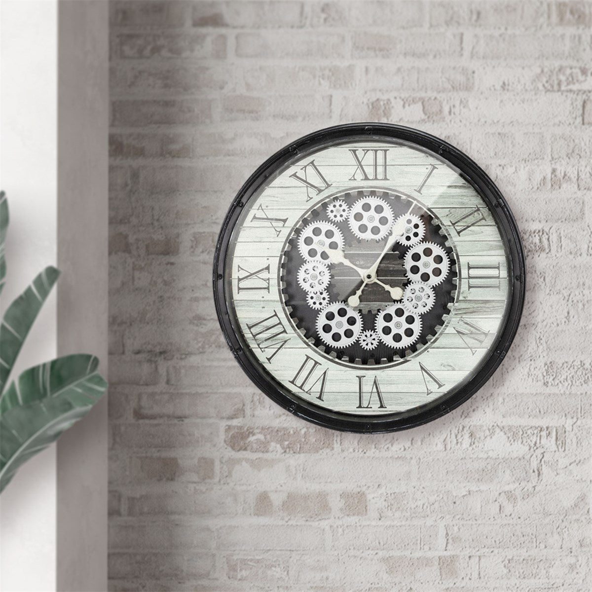 A wall clock with gears on a wooden surface, on a wall with plants.