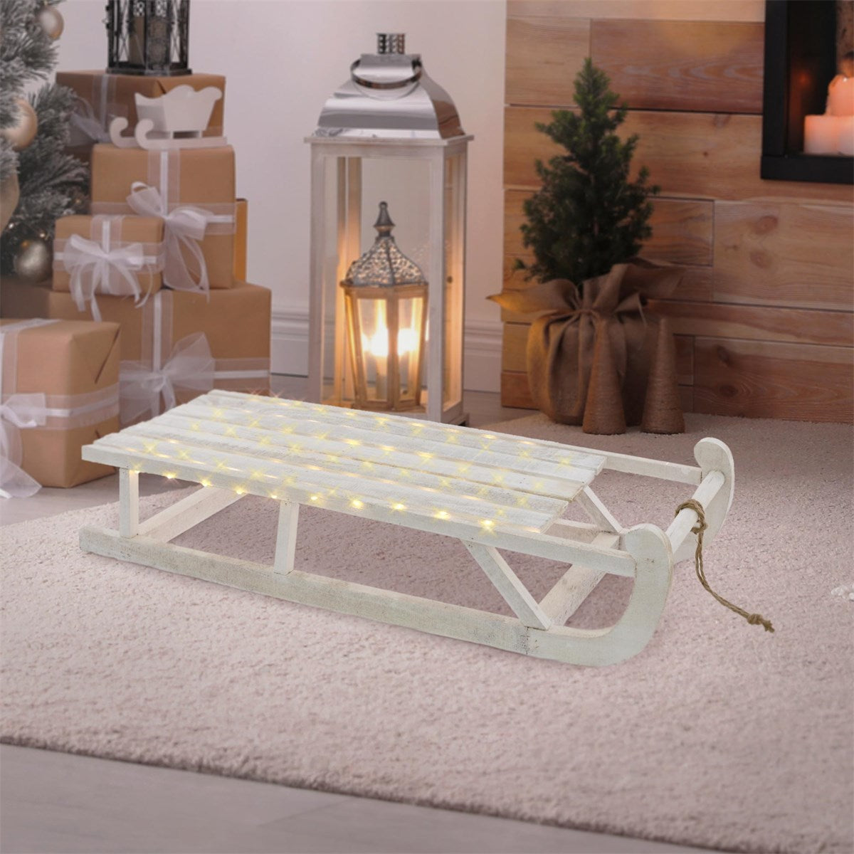 White sleigh with lights on a carpet in a room with gifts.