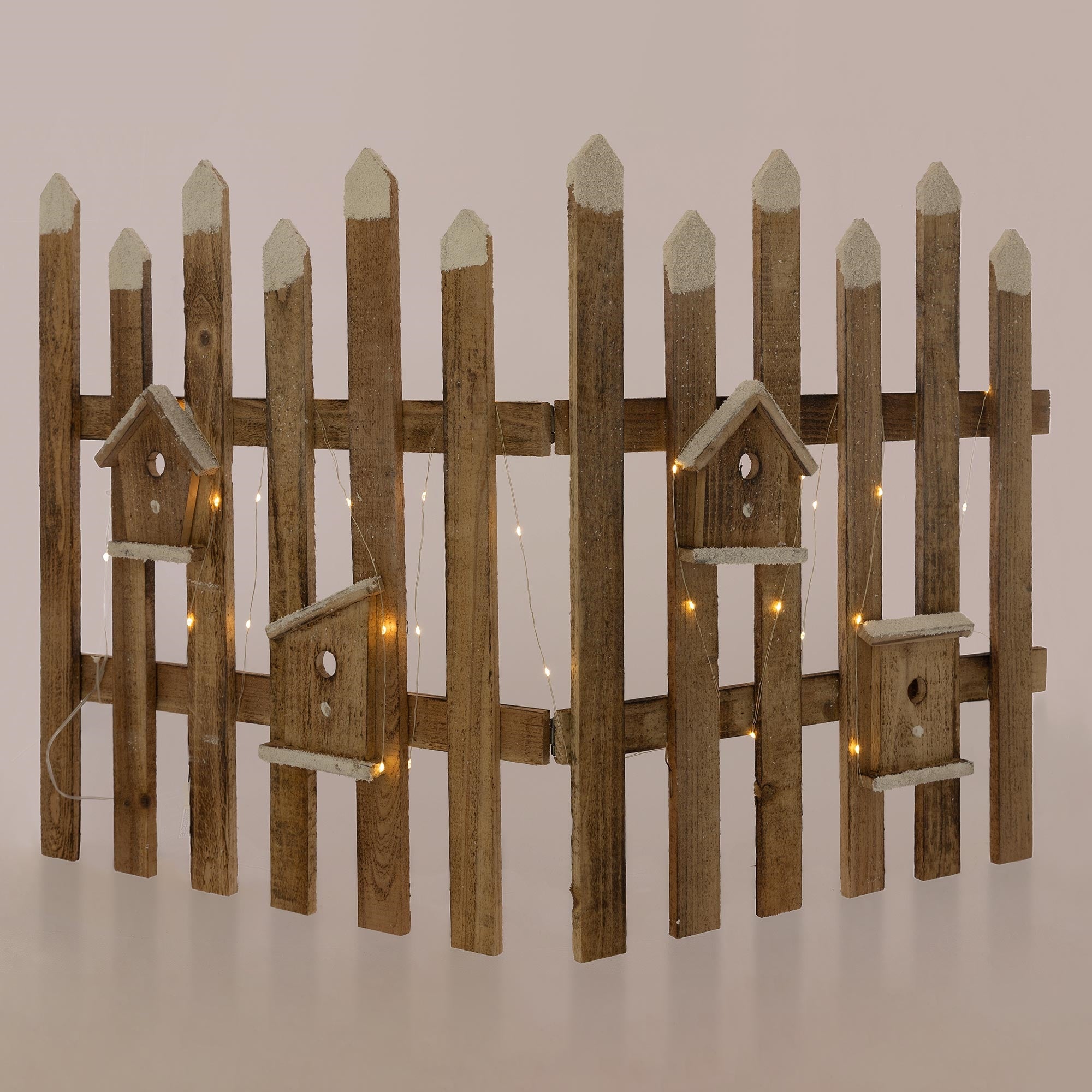 Valla de madera con pequeñas casas para pájaros y luces, en forma curvada.