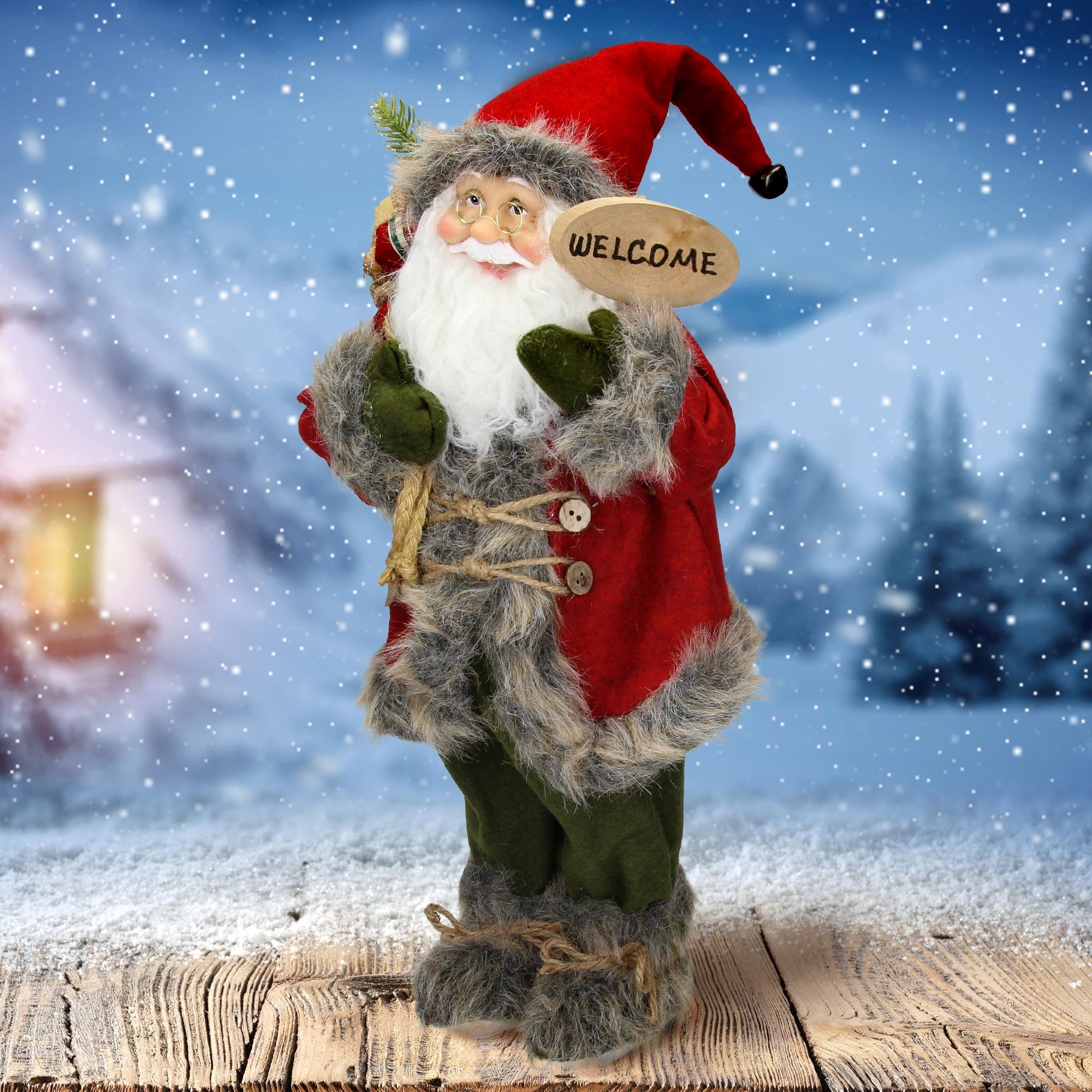 Kerstman in een rode outfit met welkomstbord, staand in een besneeuwde omgeving.