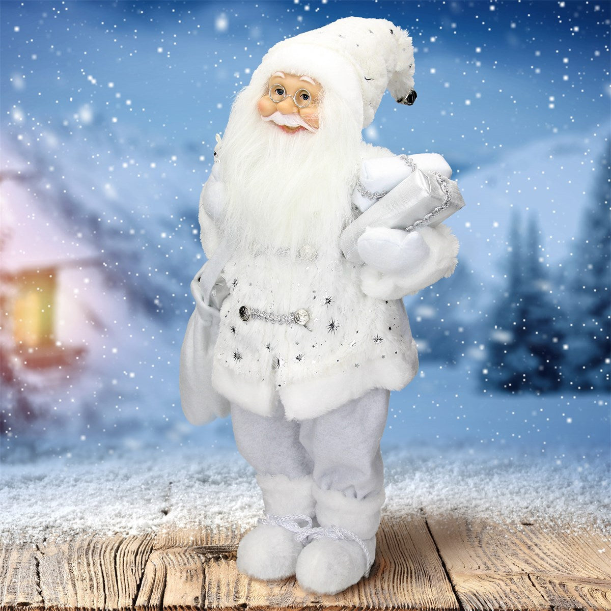 Santa Claus v bílém obleku stojící před zasněženou krajinou.