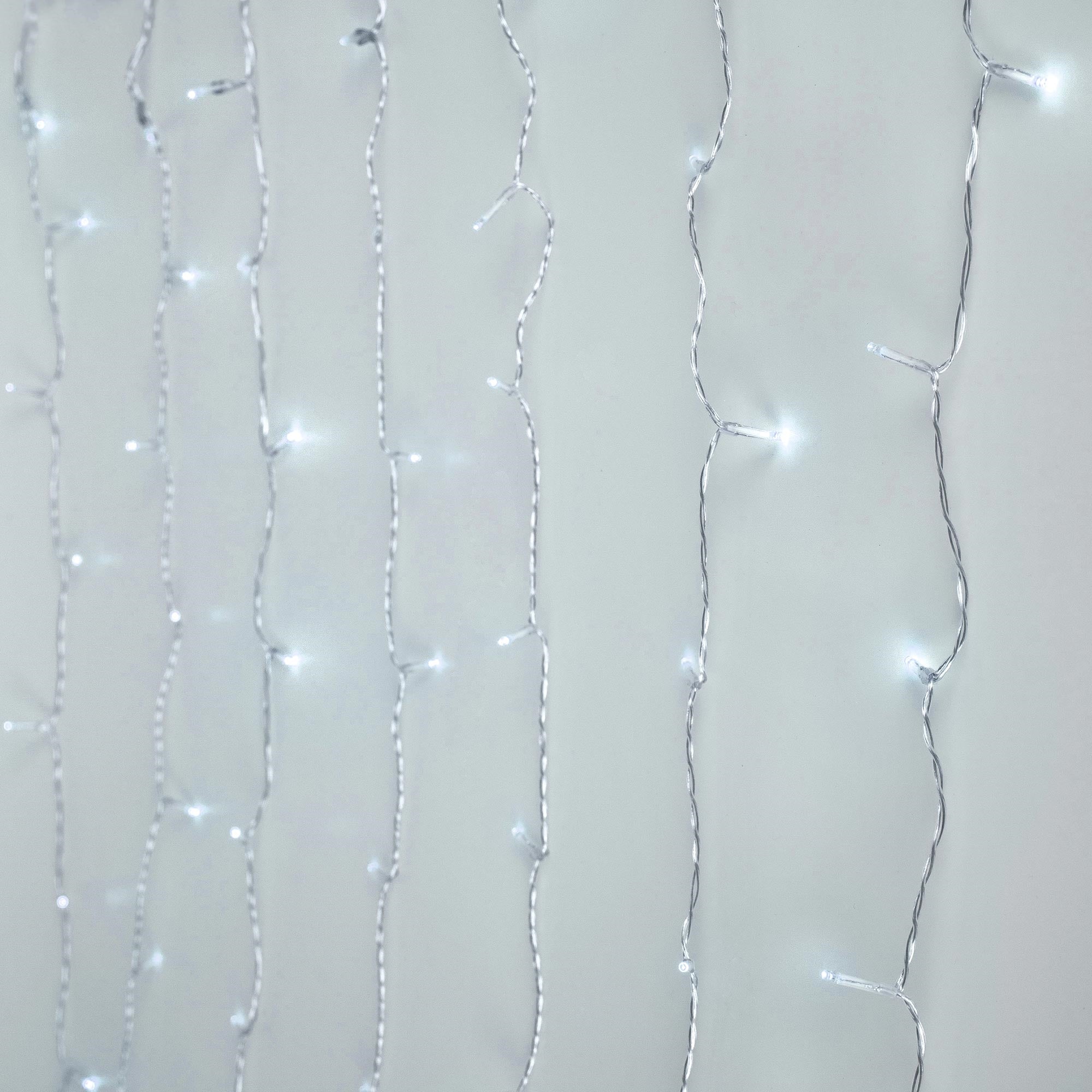Lichterkette mit kalten weißen Lichtern vor hellem Hintergrund.