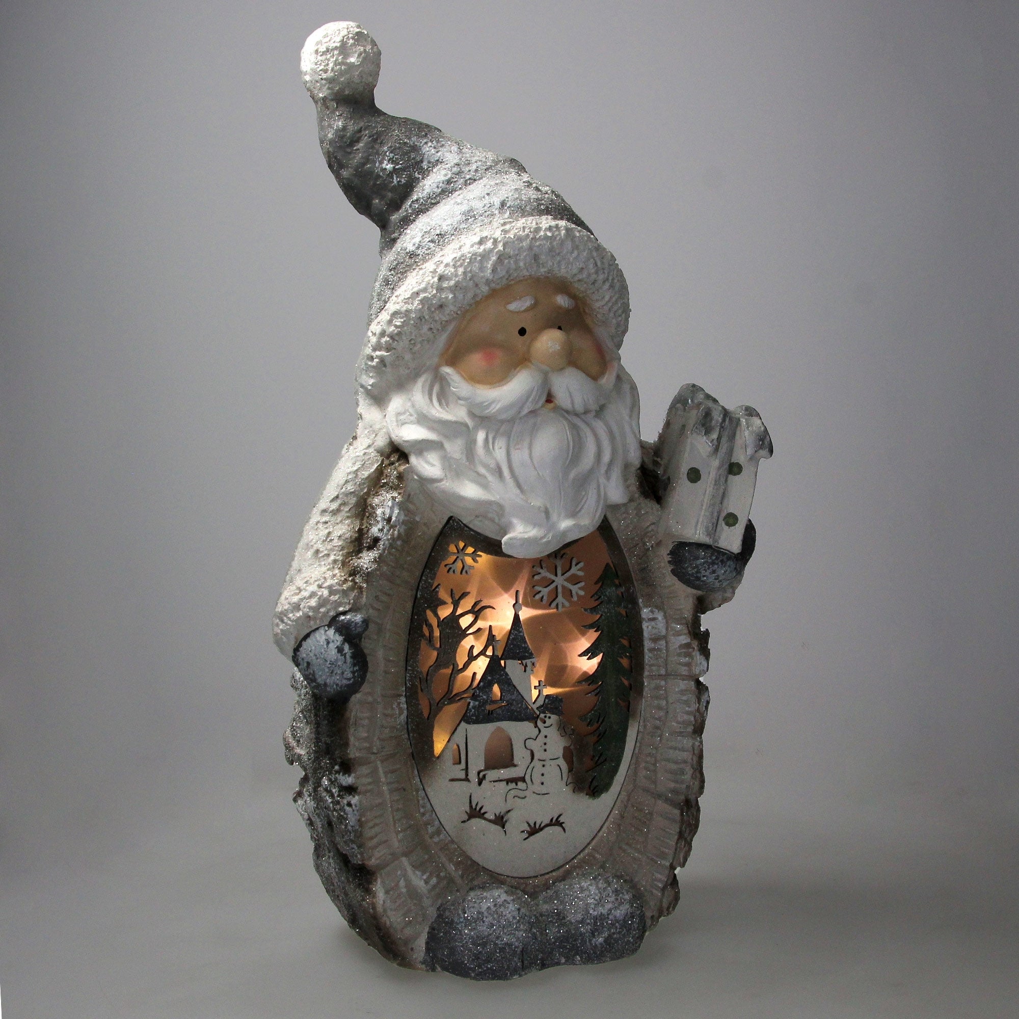 Schneemann mit Bart, Tannenbaum und beleuchtetem Winterdorf.