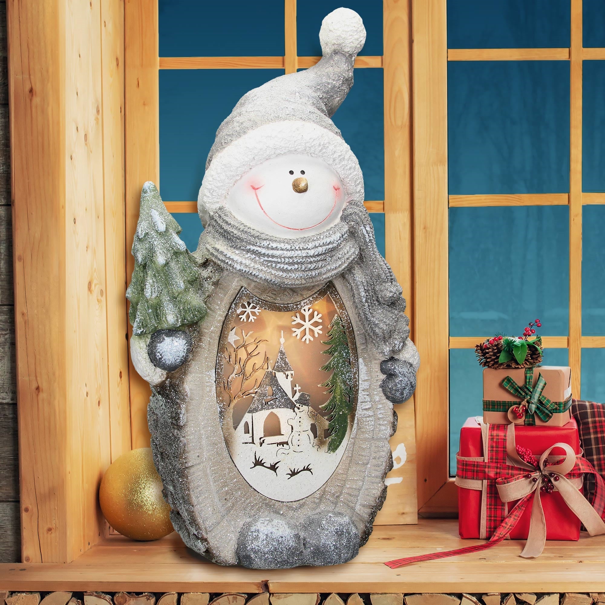 Ein weiterer Schneemann mit einem Baum, der vor einem Fenster steht, umgeben von Geschenken.