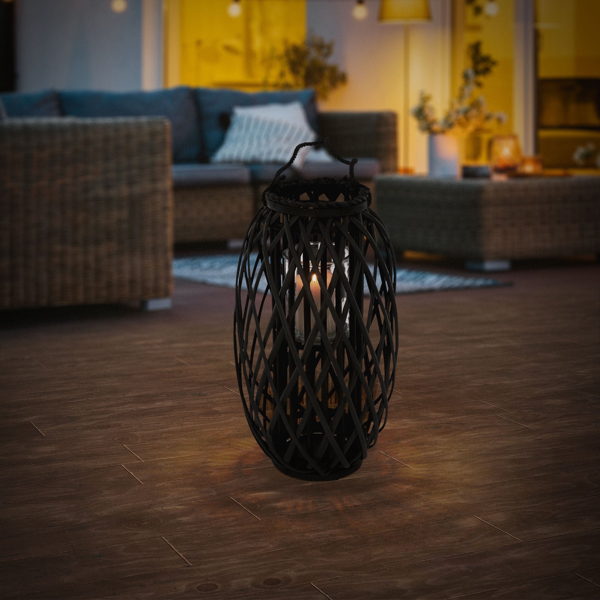 Black lantern on a wooden floor, illuminated.