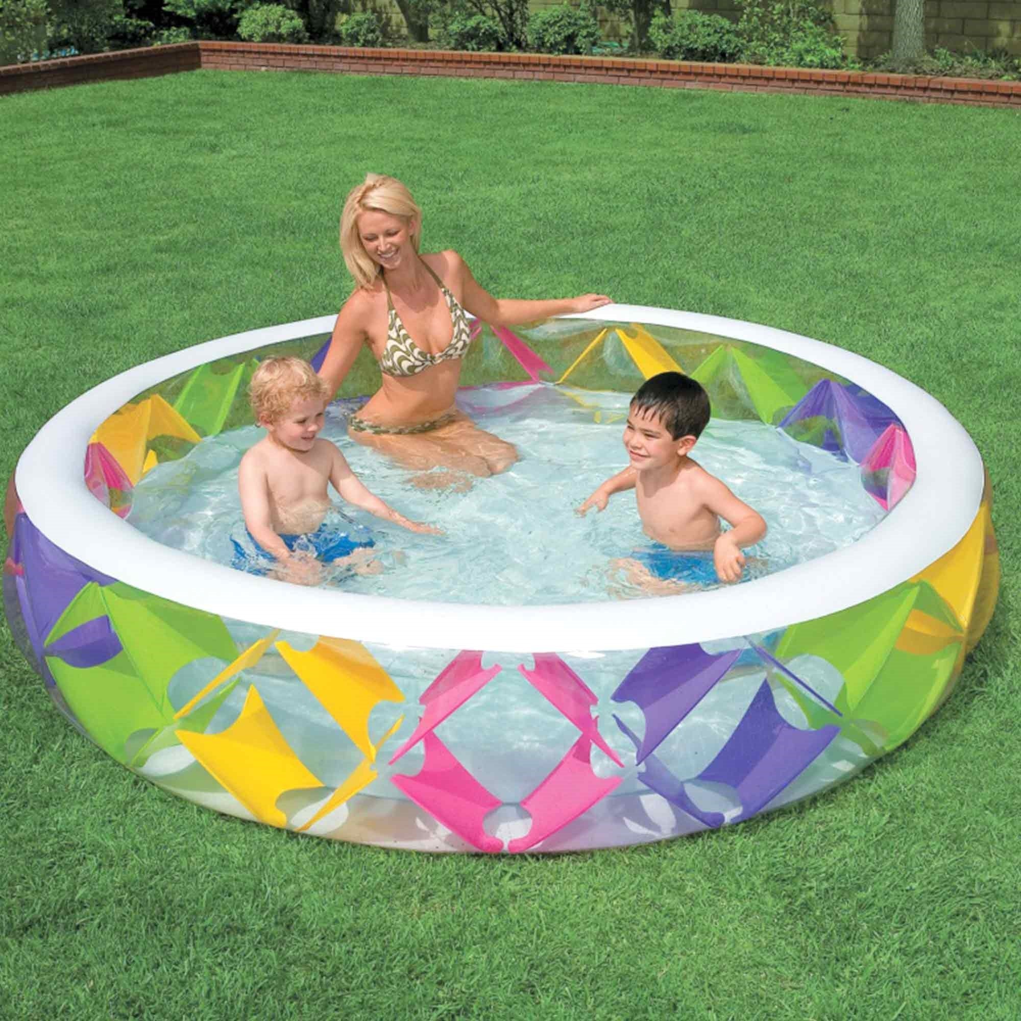 Eine Frau mit zwei Kindern in einem bunten, aufblasbaren Pool im Garten.
