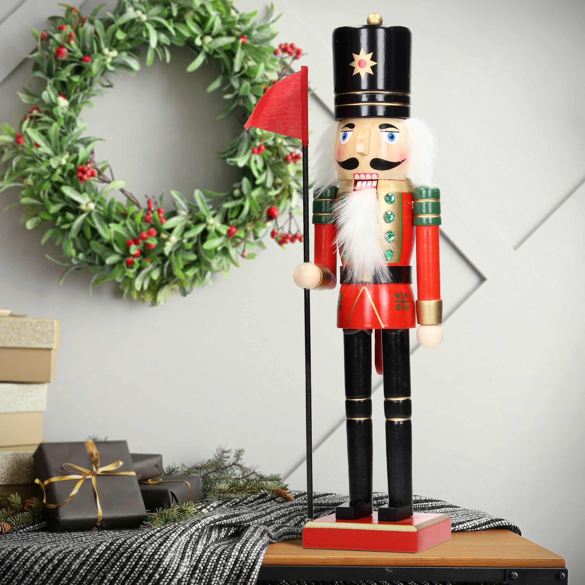 A colorful nutcracker in red and green outfit holding a flag.