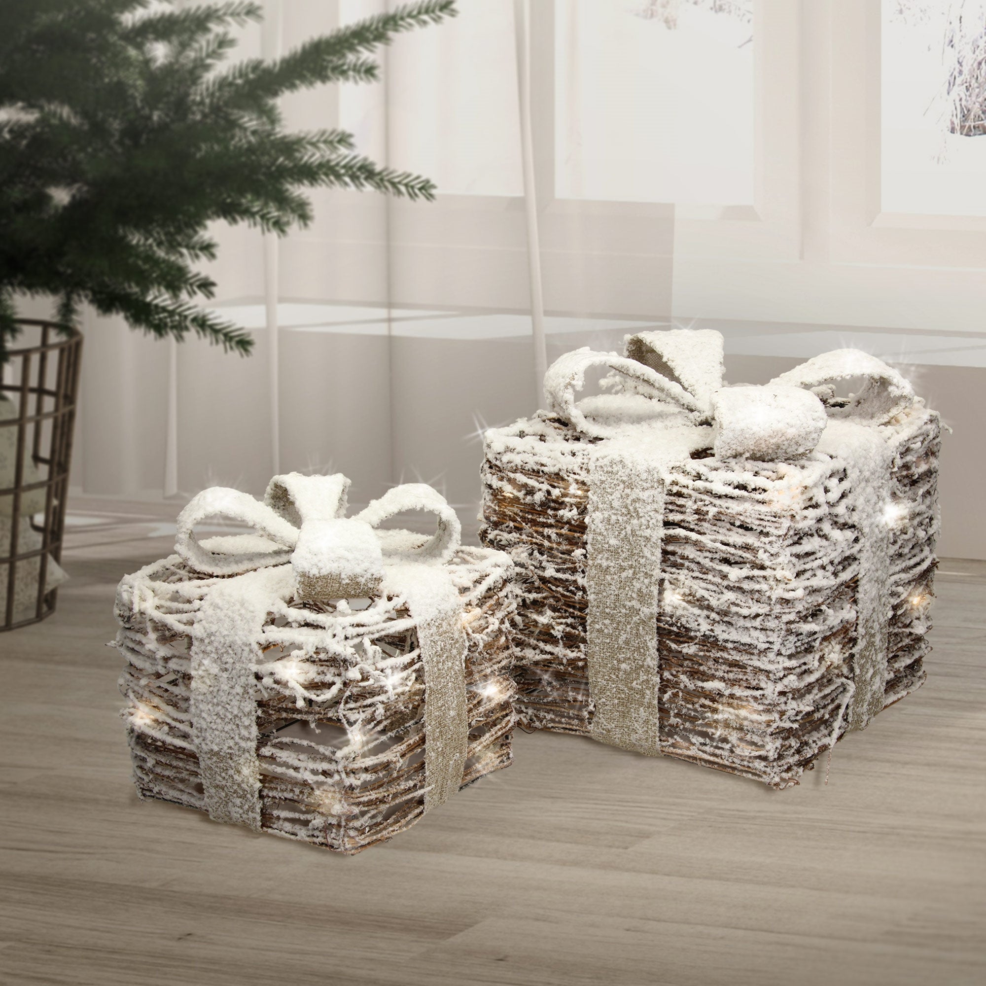 Dos paquetes de regalo con lazos, decorados con nieve, sobre un suelo.
