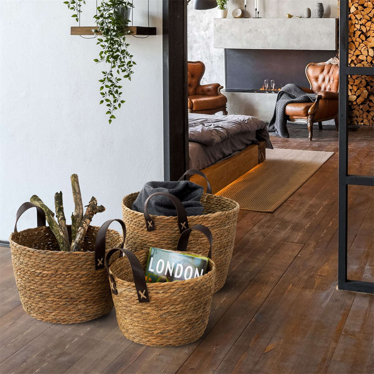 Tres cestas trenzadas en una habitación, llenas de madera y mantas.